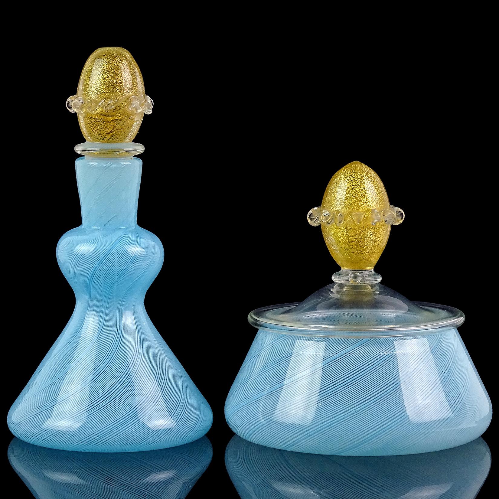 Beautiful vintage set of Murano hand blown blue ribbons and gold flecks Italian art glass vanity set. The perfume bottle and powder / jewelry box are made with very thin Filigrana ribbons in sky blue. They have gold leaf accents on each of the tops.