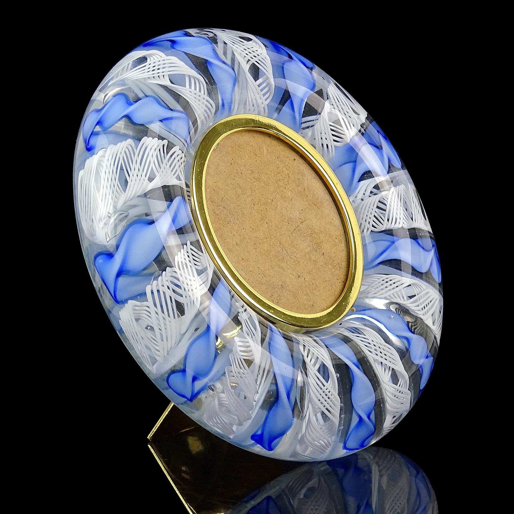 Beautiful Murano hand blown twisted blue and white Zanfirico ribbons Italian art glass desk picture frame. It has a round glass cover, a triangle stand on the back, and original Murano label on the back. The image window is a 2 1/2