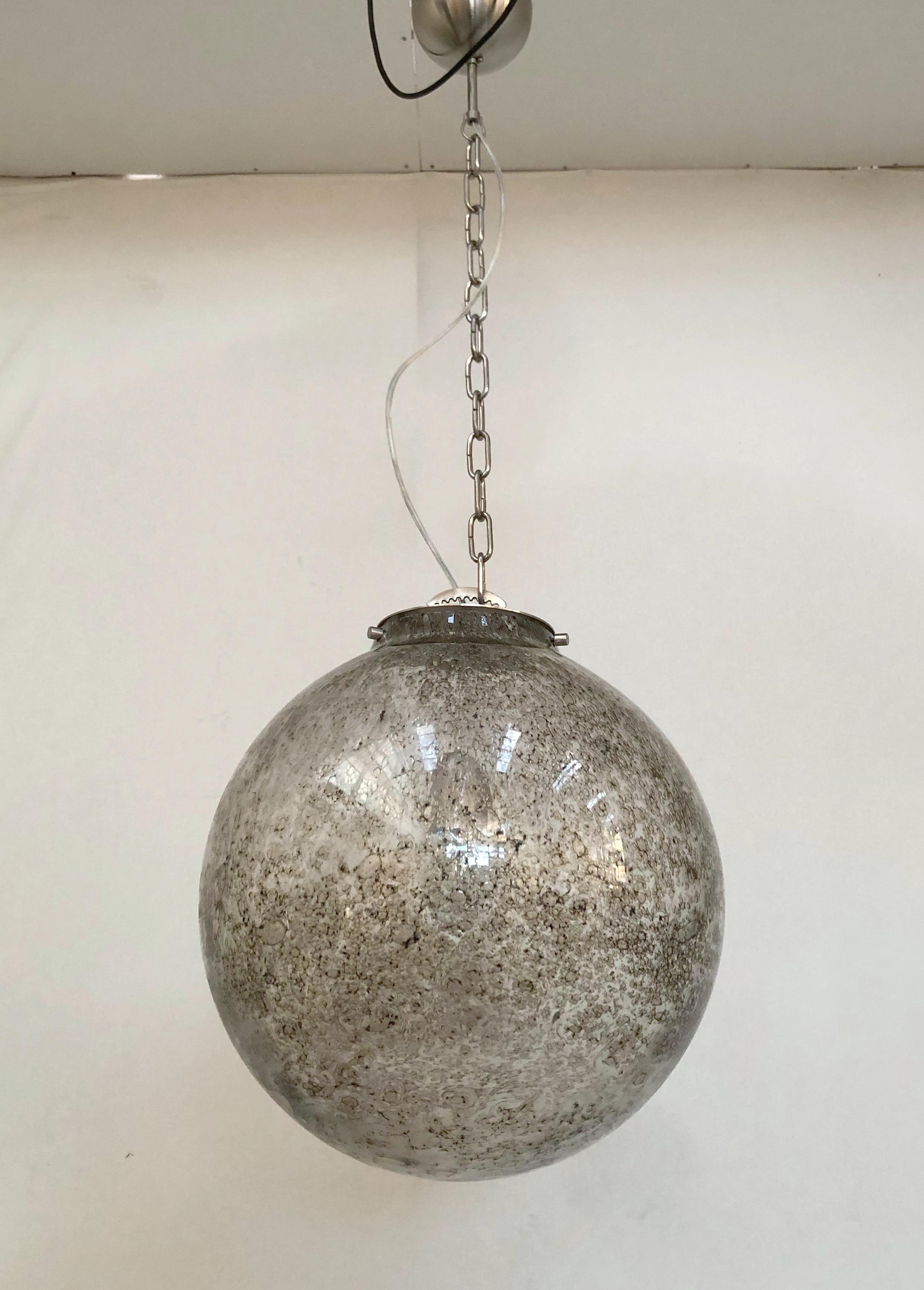 Italian pendant with a smoky Murano glass globe, carefully hand blown with bubbles within the glass using Bollicine technique, suspended from satin nickel metal chain and canopy, made in Italy
Measures: Diameter 20 inches, height 20 inches plus