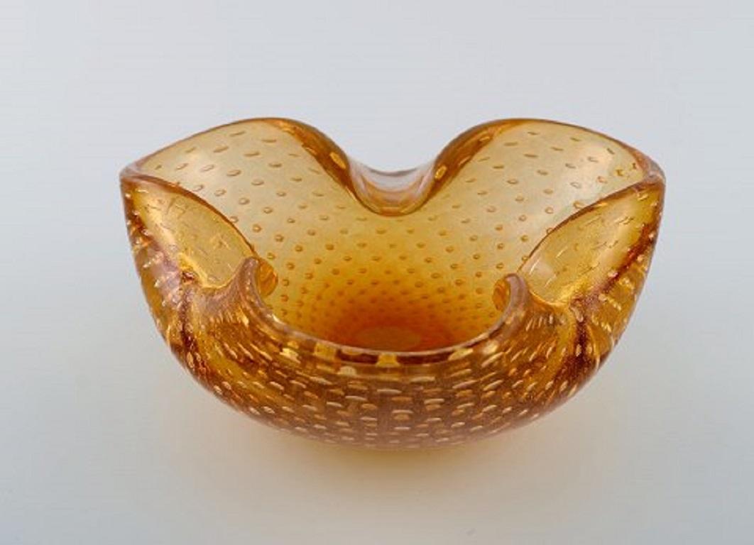 Murano bowl in amber colored mouth-blown art glass with inlaid air bubbles. Italian design, 1960s.
Measures: 16.6 x 6.5 cm.
In perfect condition.