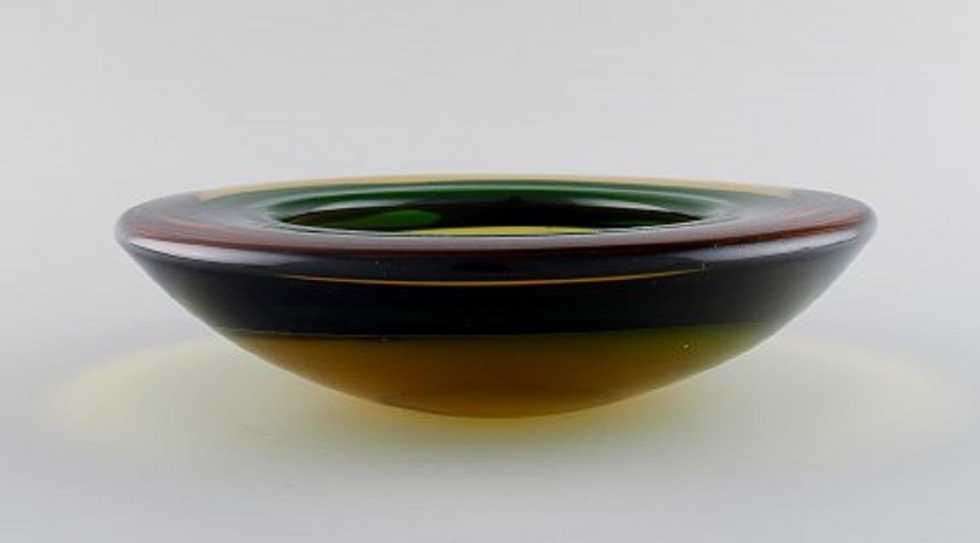 Murano bowl in mouth-blown art glass in amber and green-yellow shades. Italian design, 1960s.
Measures: 25 x 6.5 cm.
In perfect condition.