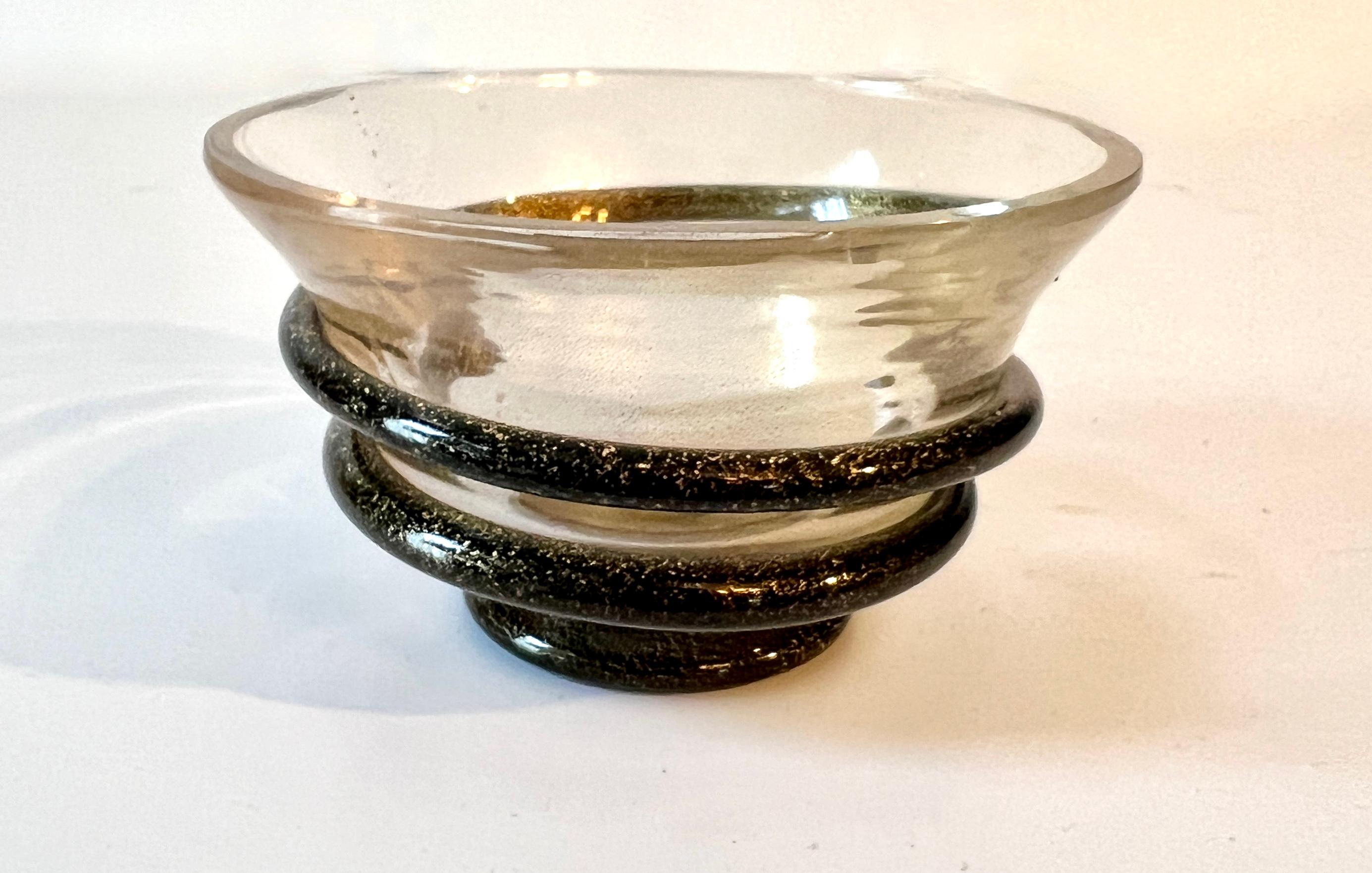 Un petit bol en verre de Murano avec des mouchetures d'or.  Le bol est entouré d'une bande allant du brun au noir.

Un complément à toute table de cocktail et au bar.  Le bol peut être purement décoratif et, en même temps, contenir tout, des noix