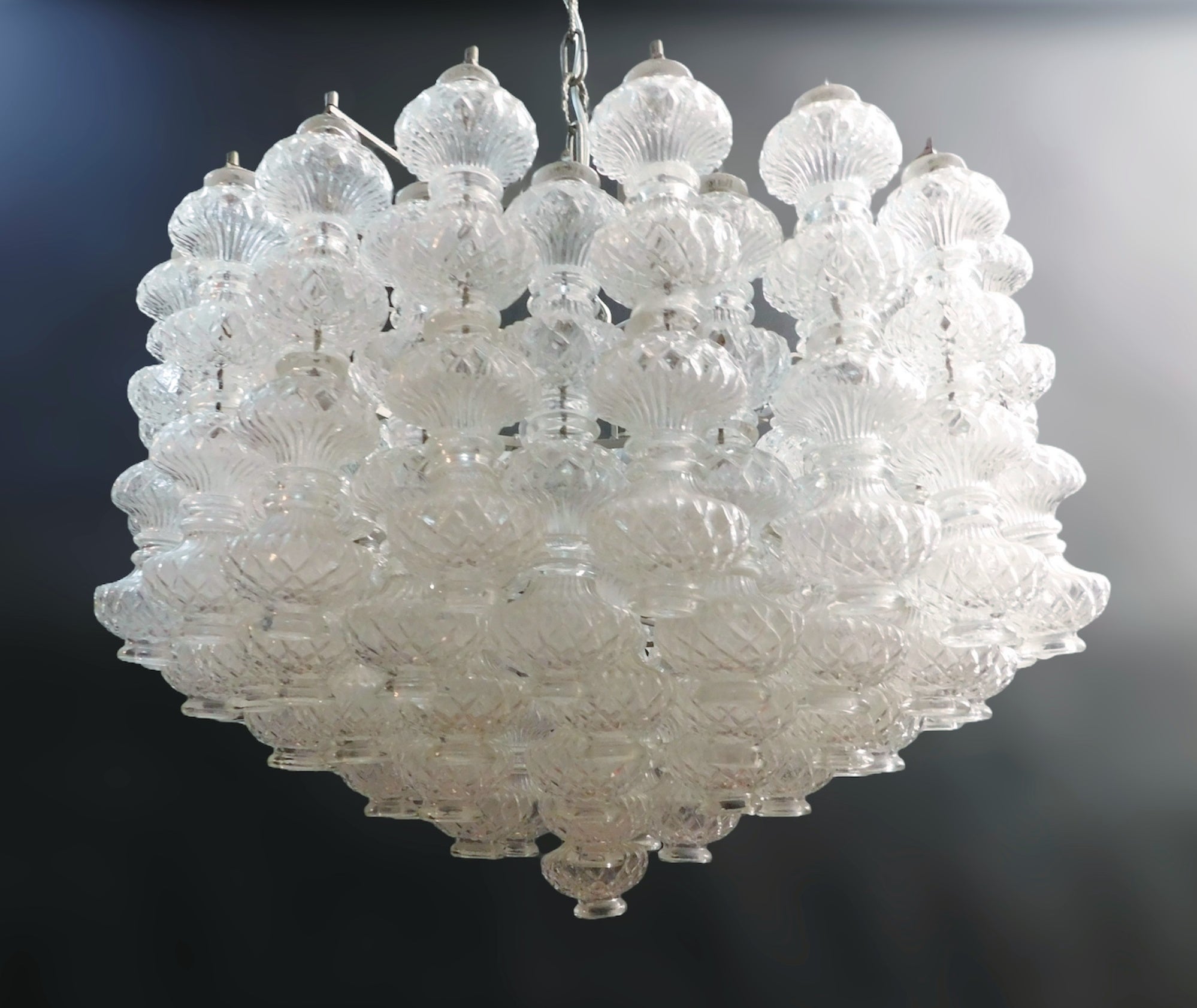 Lámpara de araña italiana de época con elementos de cristal de Murano transparente intrincadamente grabados, diseñada por Flavio Poli para Seguso / Made in Italy, circa 1960s
Medidas: diámetro 24 pulgadas, altura 16 pulgadas, altura total 31,5