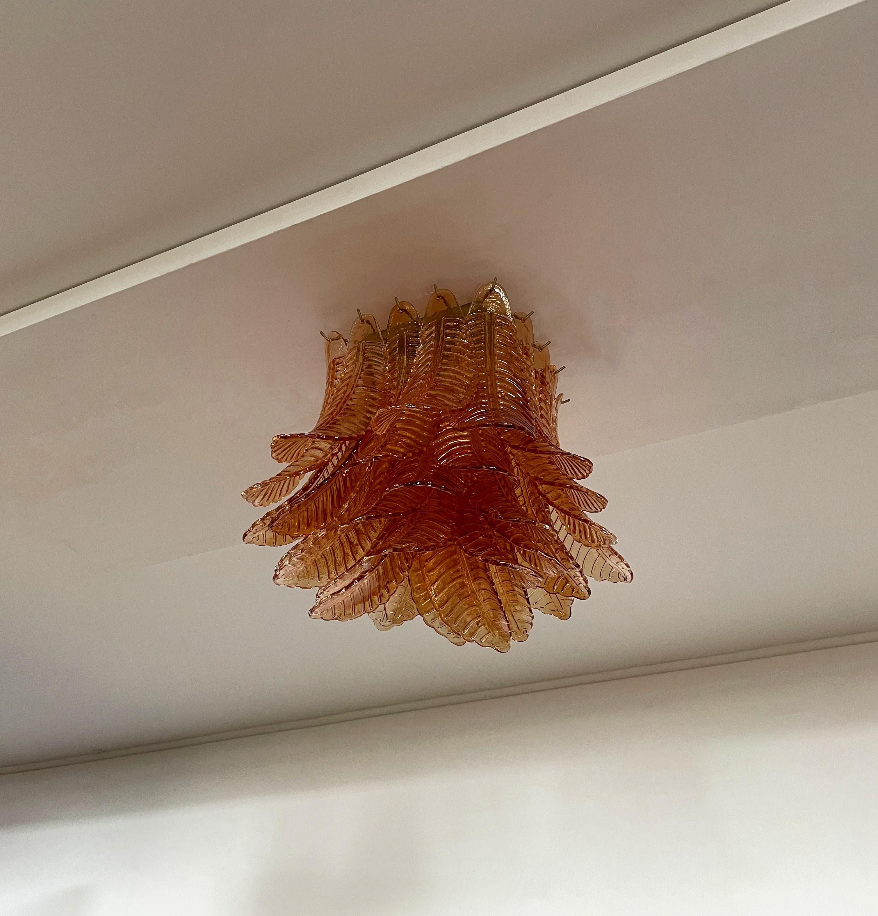 Spectacular ceiling lamp with 32 Murano ameber leaves in golden painted metal frame.  Elegant lighting object.
Period: late XX century
Dimensions: 17,50 inchs (45 cm) height; 21,30 inches (55 cm) width; 21,30 inches (55 cm) depth.
Dimension glasses: