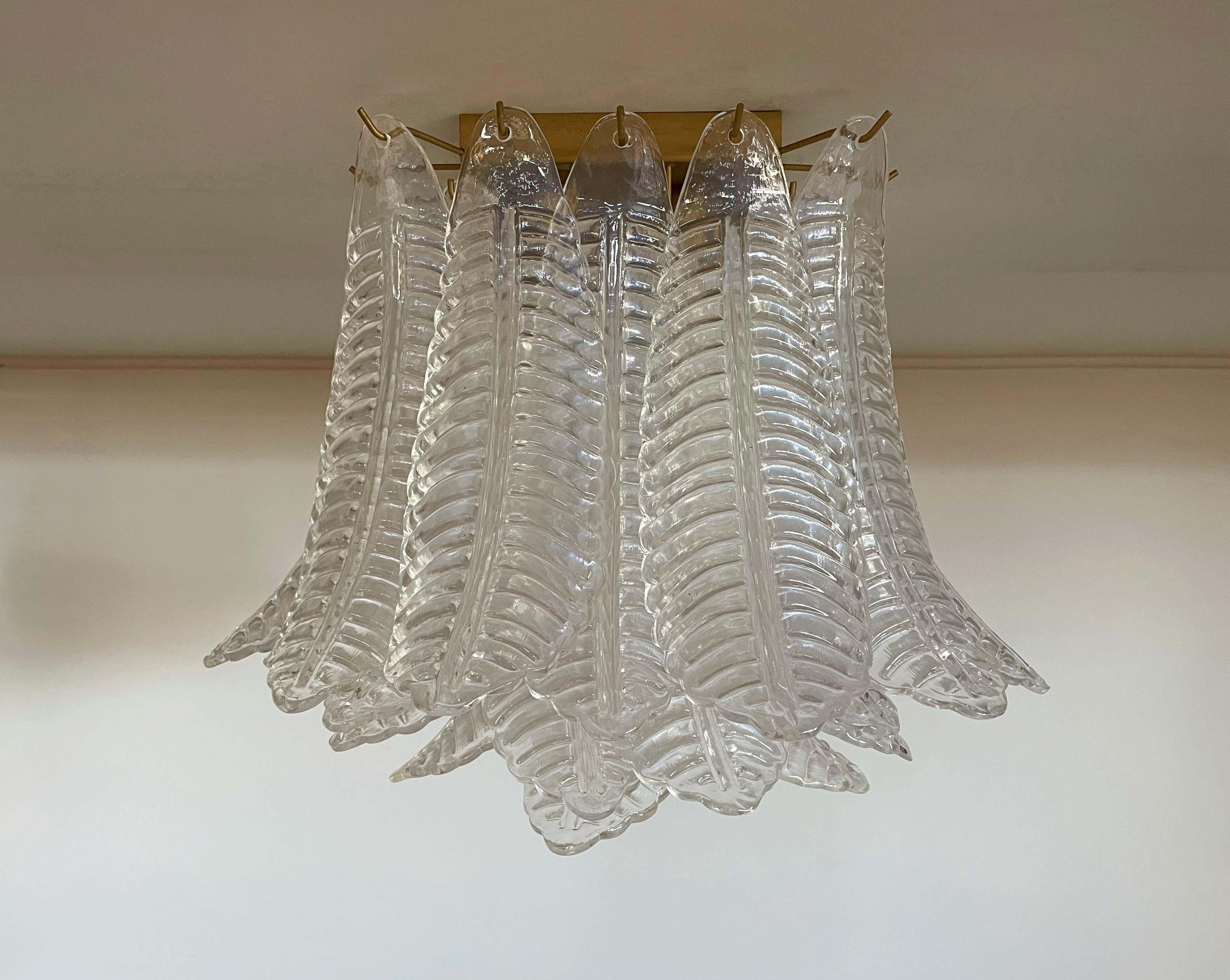 Spectacular ceiling lamp with 32 Muranotransaparent leaves in golden painted metal frame.  Elegant lighting object.
Period: late XX century
Dimensions: 17,50 inchs (45 cm) height; 21,30 inches (55 cm) width; 21,30 inches (55 cm) depth.
Dimension