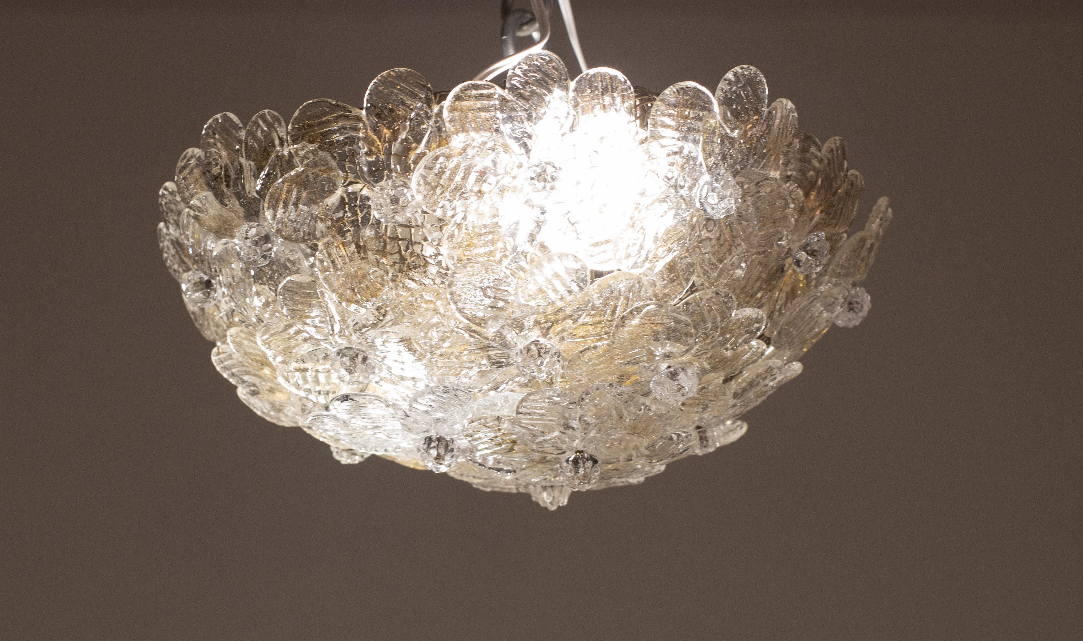 Bonita lámpara de techo de dos luces con flores de cristal de Murano, fabricada por Seguso para Venin, Italia, años 60.
Cesta de techo metálica con tema de flores superpuestas de cristal de Murano soplado a mano en color dorado y transparente con