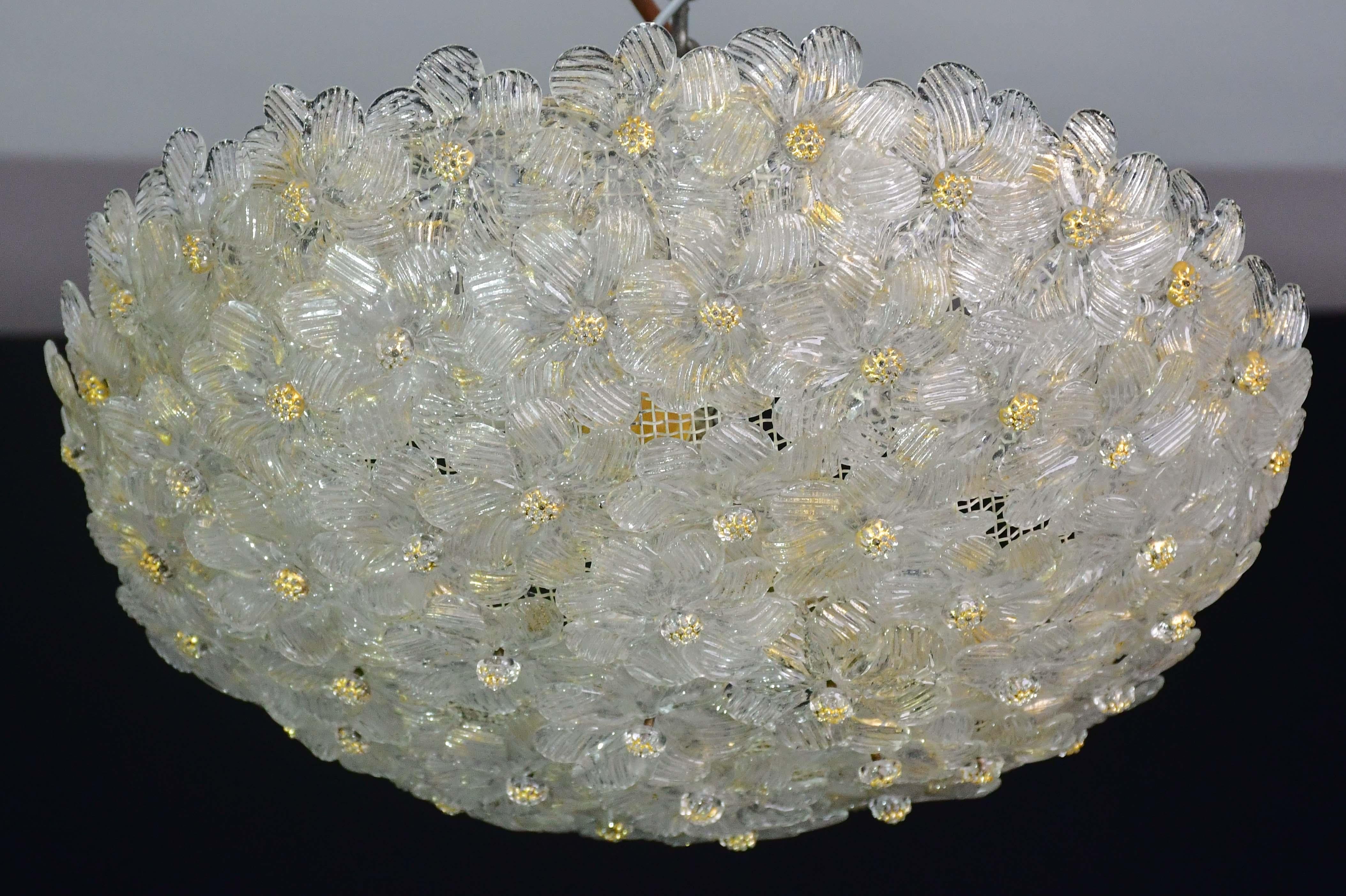Hübsche zweiflammige Deckenleuchte mit Blumen aus Murano-Glas, hergestellt von Seguso für Venini, Italien, 1960er Jahre.
Deckenkorb aus Metall mit überlappenden Blumen aus mundgeblasenem Murano-Glas in Gold und transparenter Farbe mit goldenen