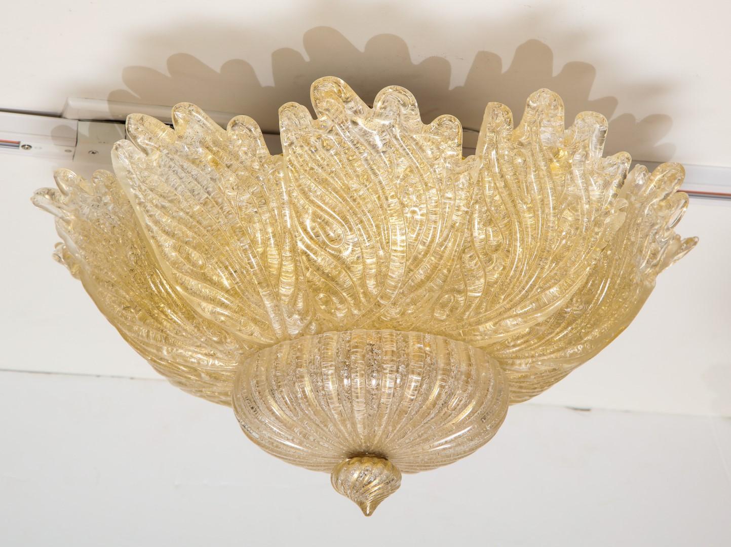 A Venetian Murano flower form ceiling light, handblown leaf-form golden powder glass panels, centring a spiral form finial.