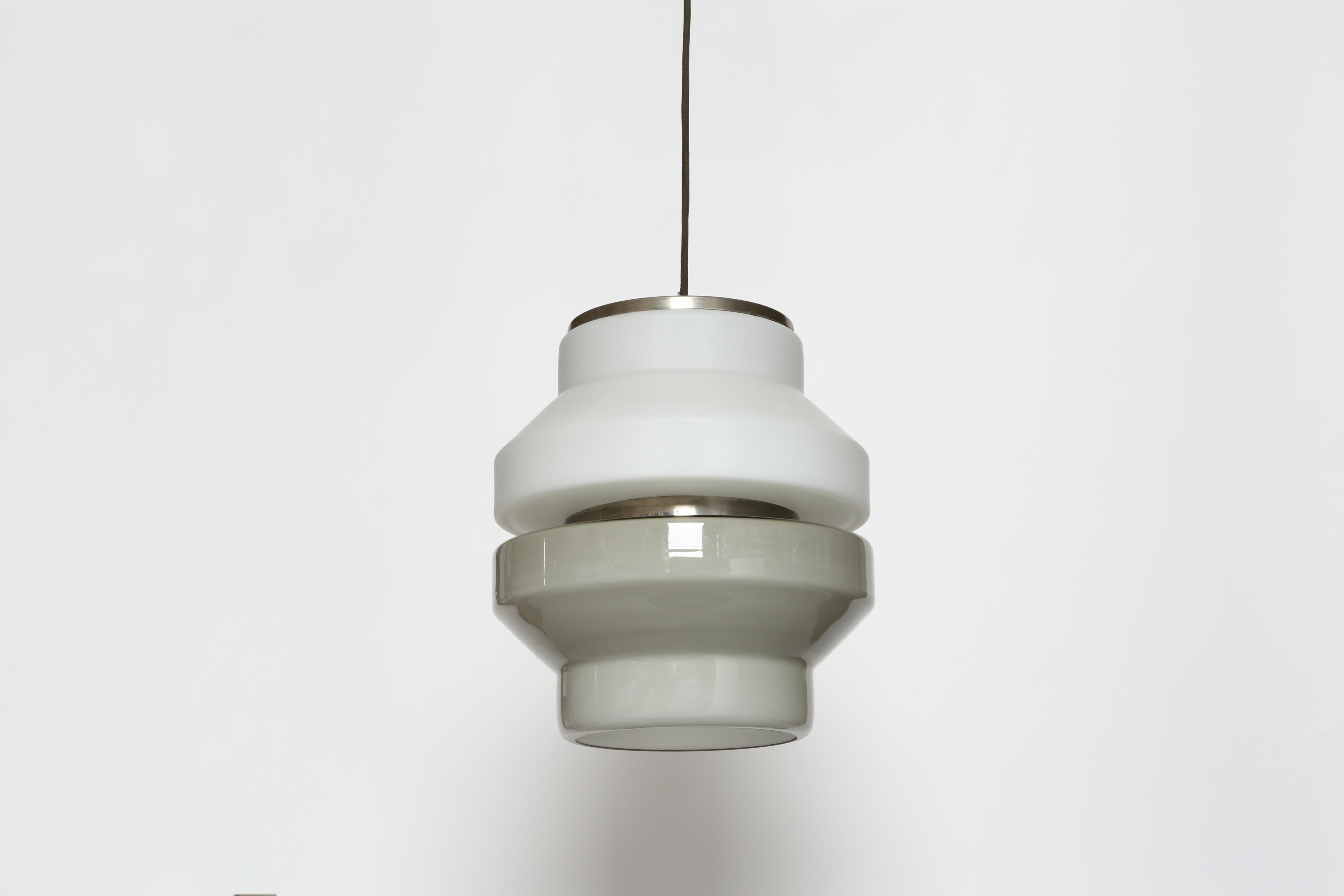 Murano glass ceiling pendant by Vistosi.
Designed and made in Italy in 1960s.
Two tone Murano glass in grey and white.
Takes one medium base bulb.
Complimentary US rewiring upon request
Height of the glass is 13 inches.
Overall drop is adjustable,