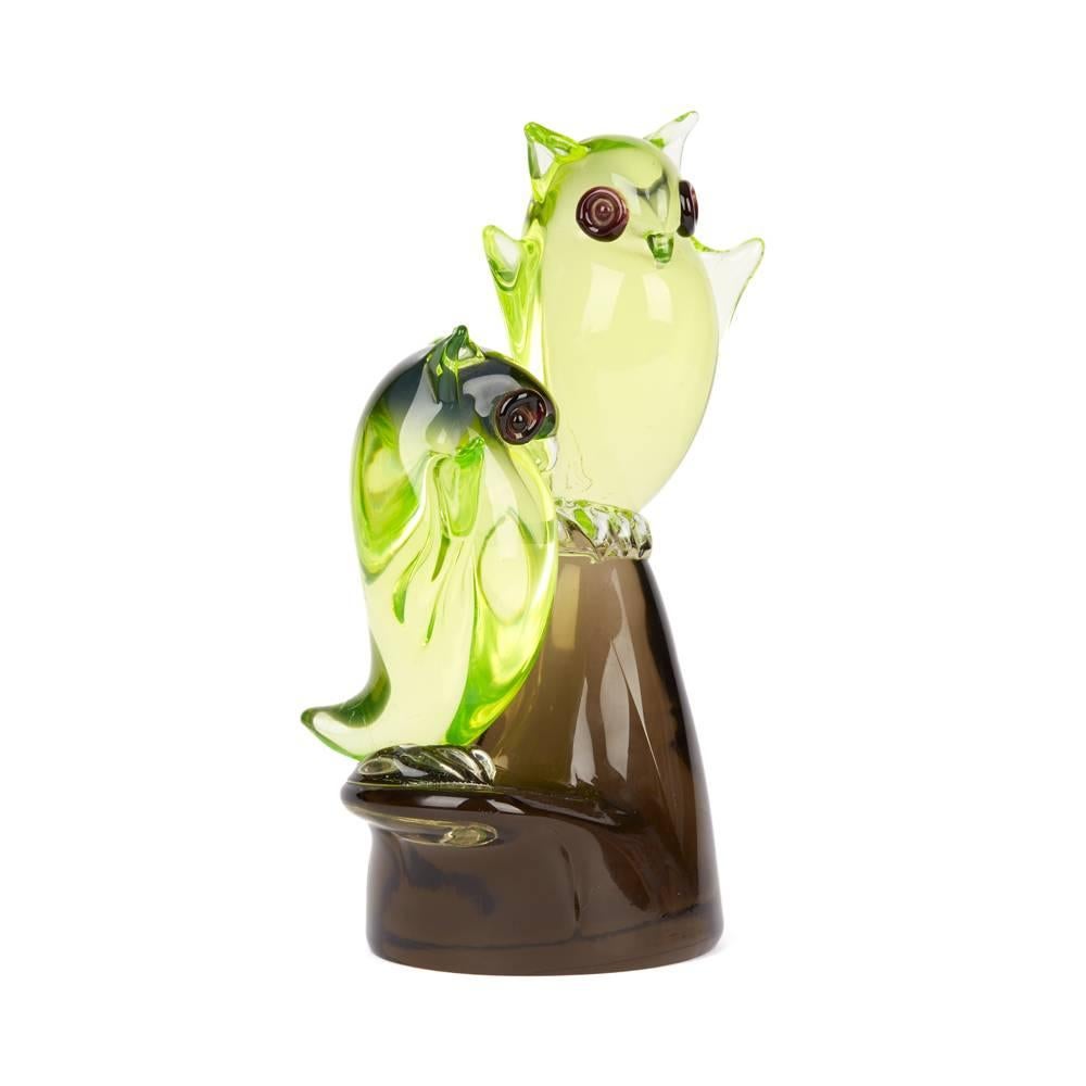 An unusual and interesting Murano, Cenedese attributed glass sculpture of two cute owls on a perch. In translucent yellow glass with large red glass eyes the owls have small raised ears and small open wings and are sat on a shaped solid tinted brown