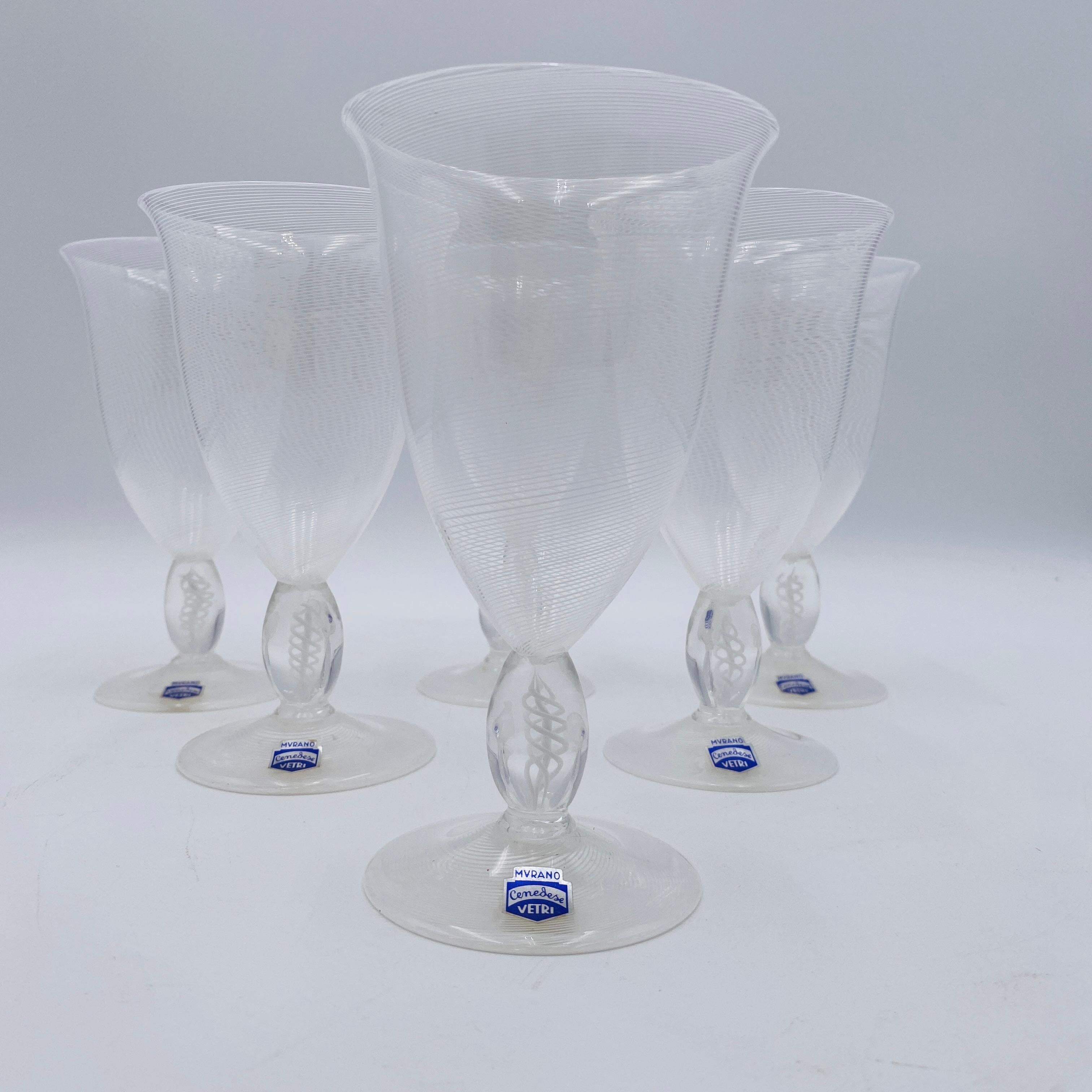 This image shows a set of Murano Cenedese Vetri wine glasses made in Italy. These are likely made from lead-free crystal, known for clarity and resonance. The distinctive white, swirled pattern suggests a 