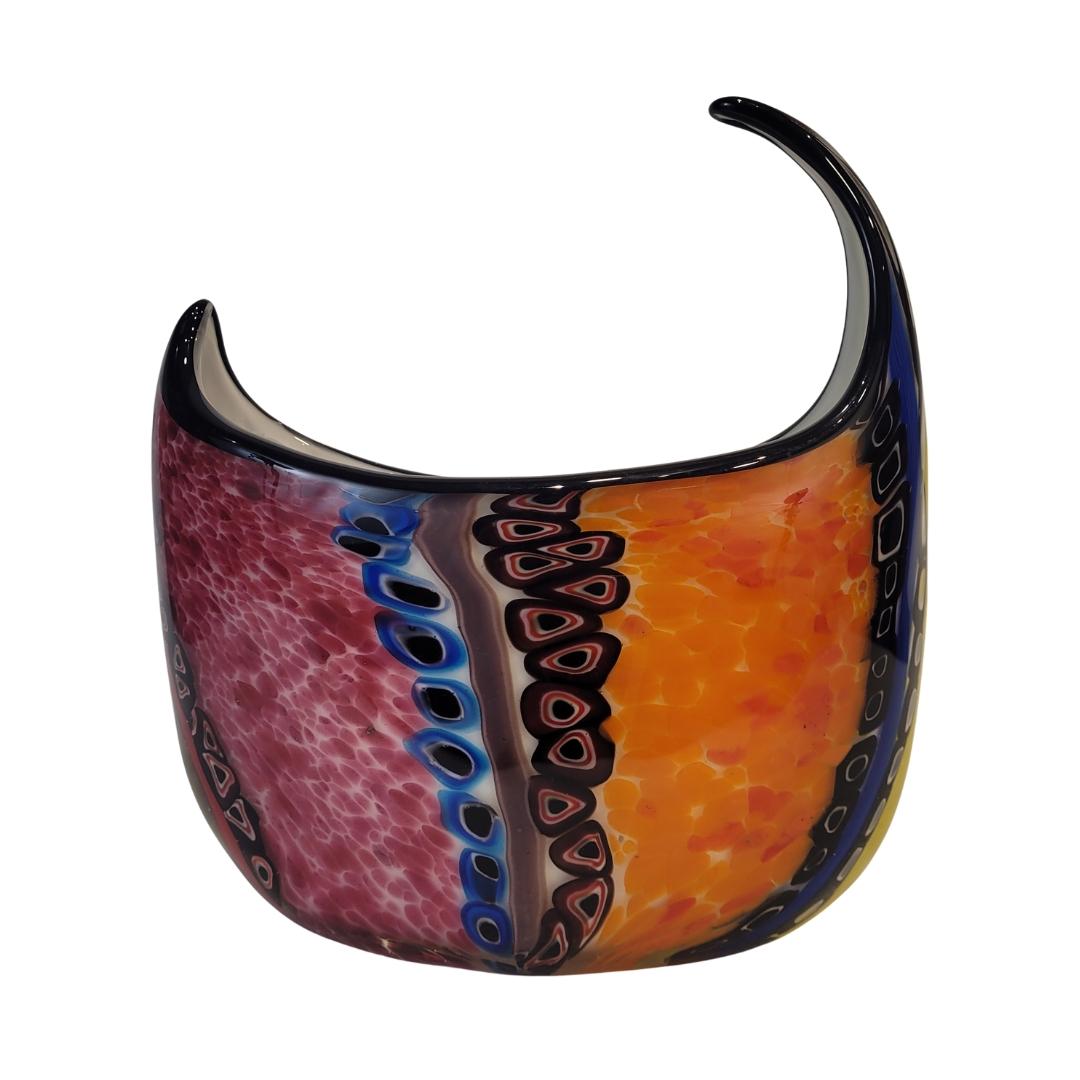 Bello  un centrotavola o vaso decorativo unico a forma di mezzaluna, realizzato in vetro di Murano con la tecnica millefiori, originaria dell'Italia degli anni '90.

Il pezzo presenta una curiosa forma a mezzaluna distorta, con un ventre profondo e