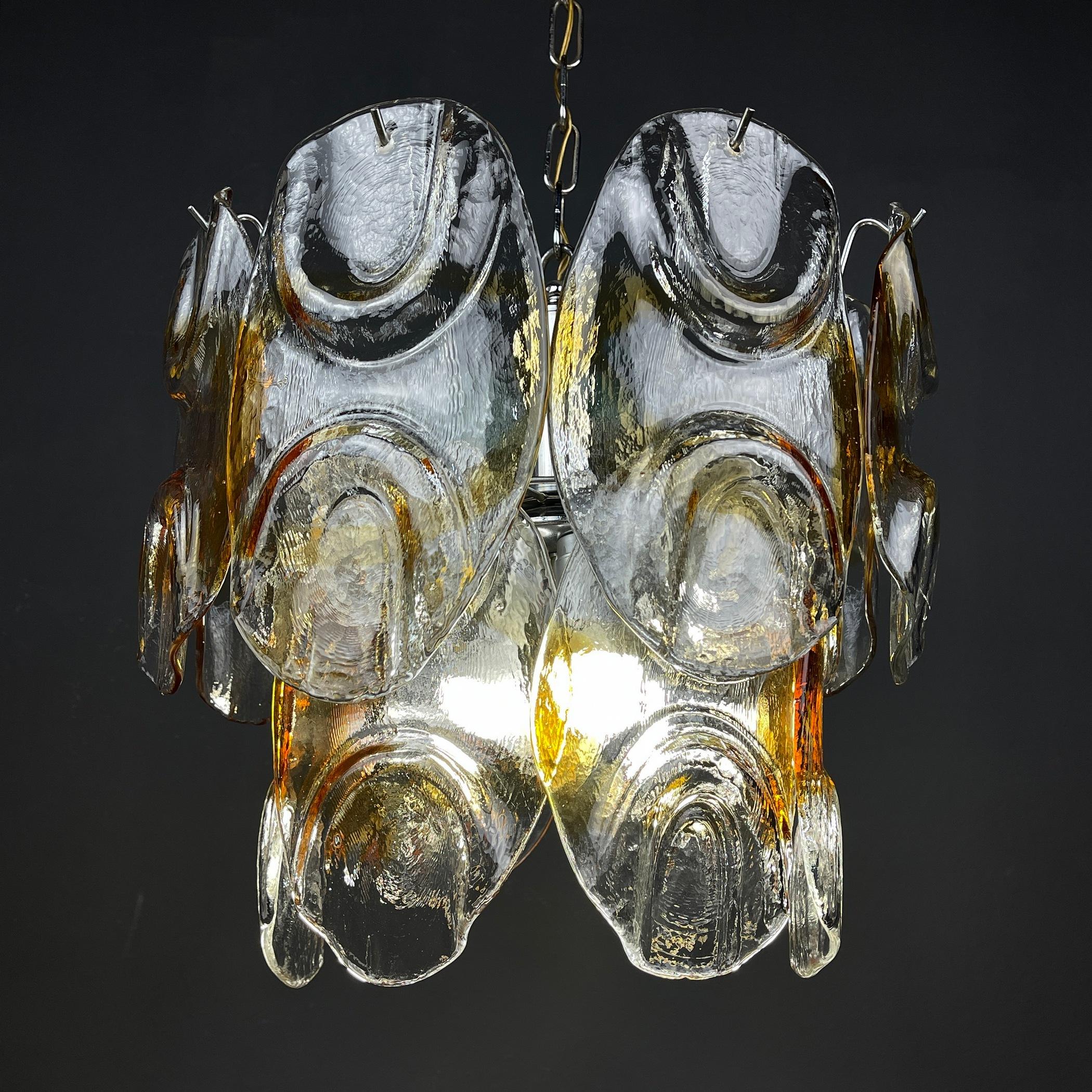 The absolutely fantastic vintage Murano glass chandelier by Mazzega made in Italy in the 1960s. Consists of 14 glass plates of Murano glass, made by Italian glassblowers. They follow the oldest Murano glassmaking technologies that were invented on