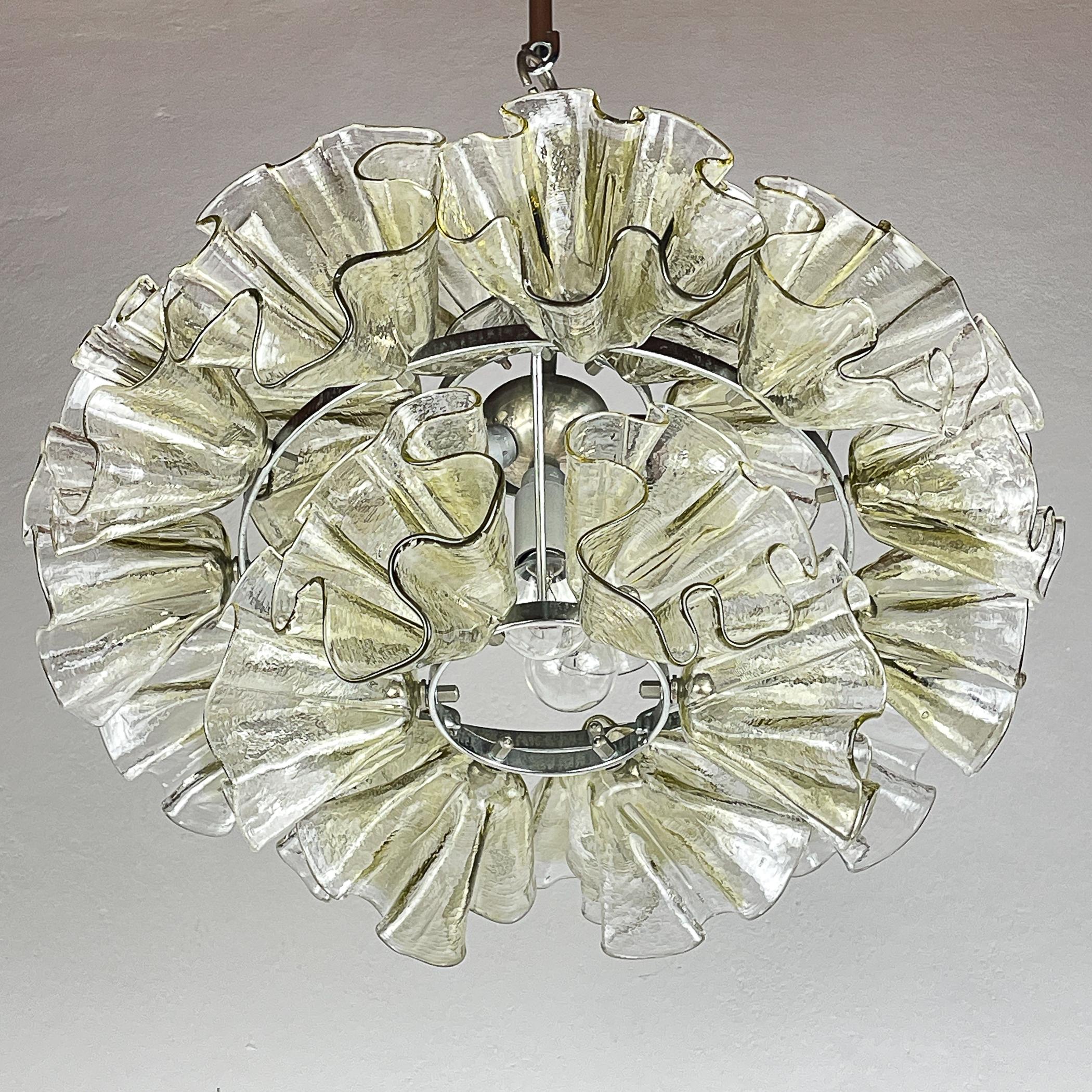 Introducing a mesmerizing Murano chandelier crafted by Mazzega in Italy during the 1970s, representing the epitome of mid-century modern Italian lighting. This exquisite chandelier features 23 meticulously handcrafted flower-shaped elements, each