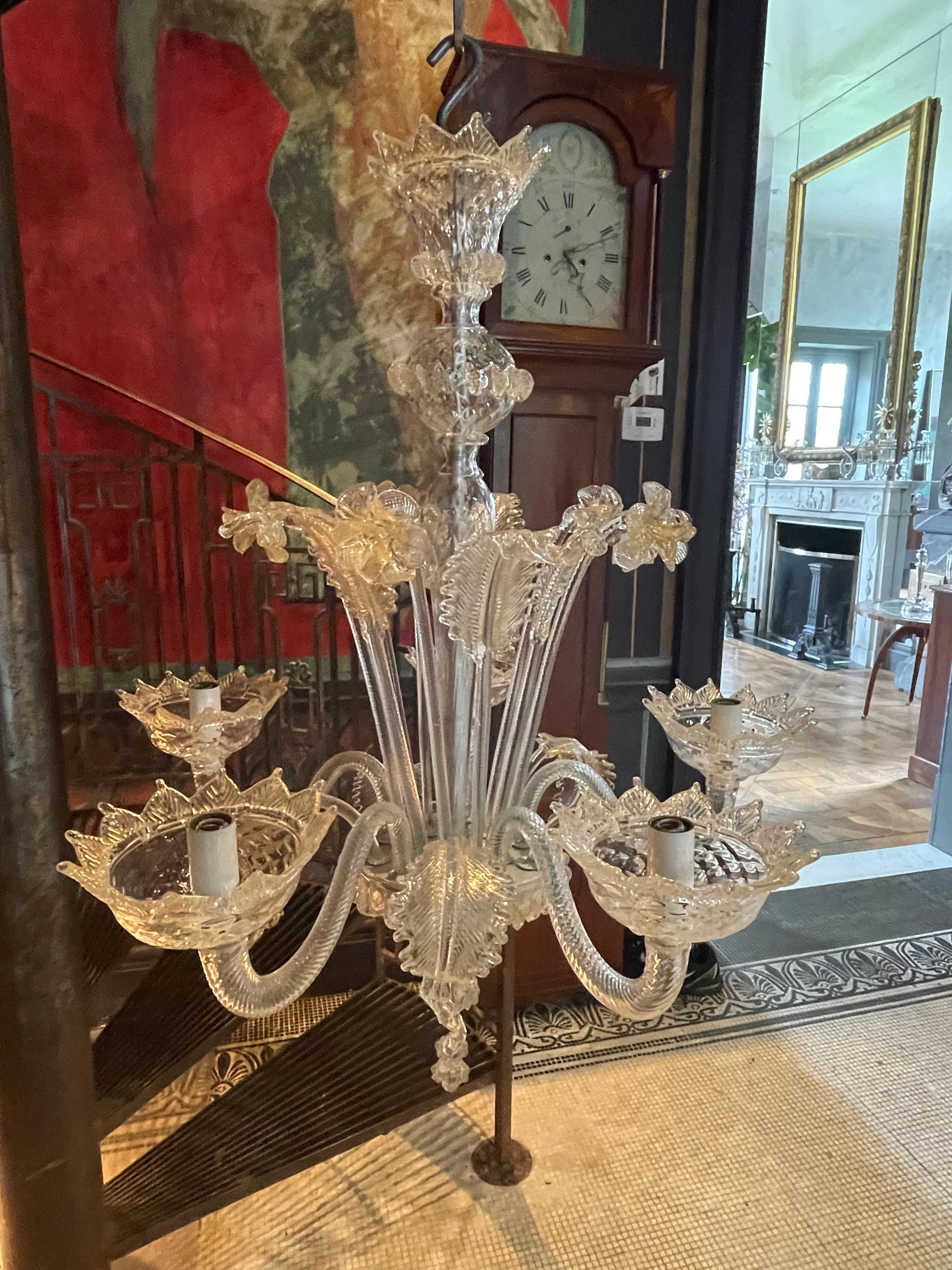 This traditional elegant five-arm chandelier was manufactured in Venice by the Venini Family in the 1950s. It is made of clear glass with 24-karat gold inclusions.