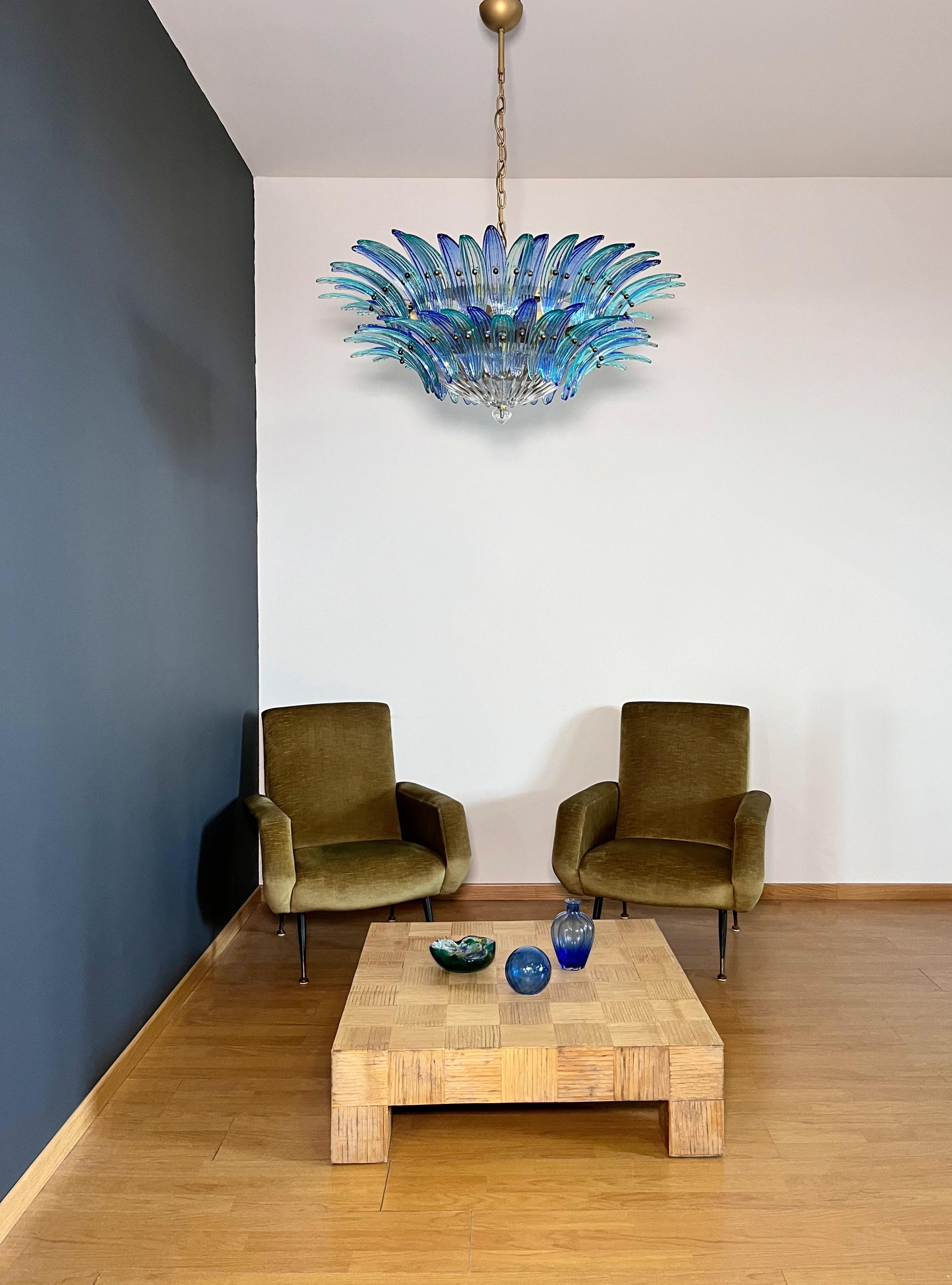 Luxury and GENUINE Murano Glass chandelier. HAND MADE IN MURANO. It made by 82 Murano blue and turquoise glasses, two levels,  in a gold painted metal frame.  The chandelier has also a Murano clear glass base in the end of the lamp. Murano blown
