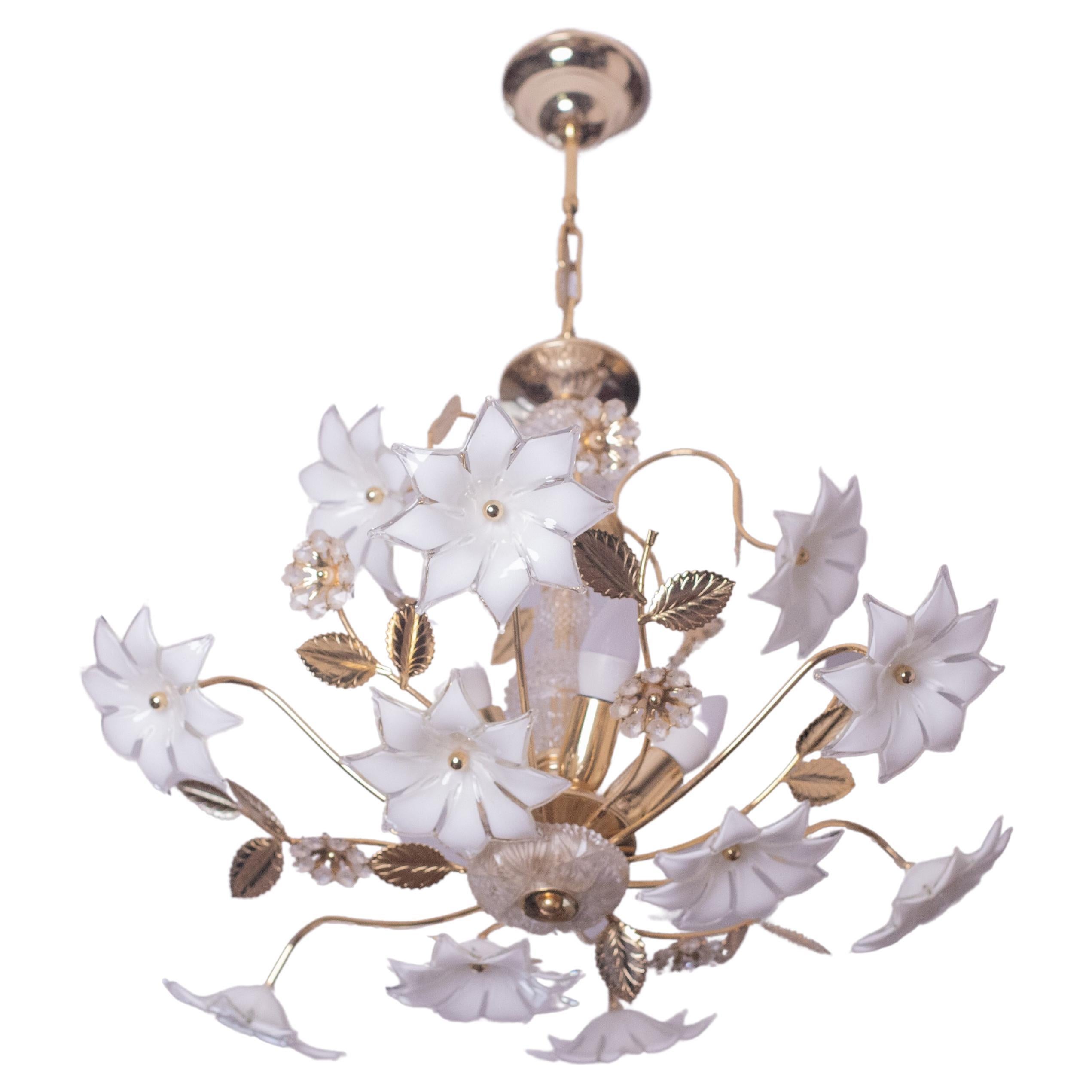 Lustre vintage en verre de Murano rempli de fleurs en verre blanc et en cristal, avec la structure centrale recouverte de cristal.
Le lustre comporte 5 points lumineux avec une douille E14.
La structure est en bain d'or, en excellent état