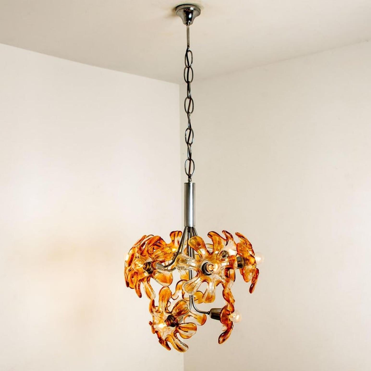 Elegant Murano chandelier by Mazzega, 1960s. Chrome chain and hardware. Amber and clear resembles flowers. The chandelier illuminates beautifully on wall and ceiling. Measures: Ø 19 inch/ 48 cm, 24 inch H 60 cm

Cleaned well wired and ready to use.
