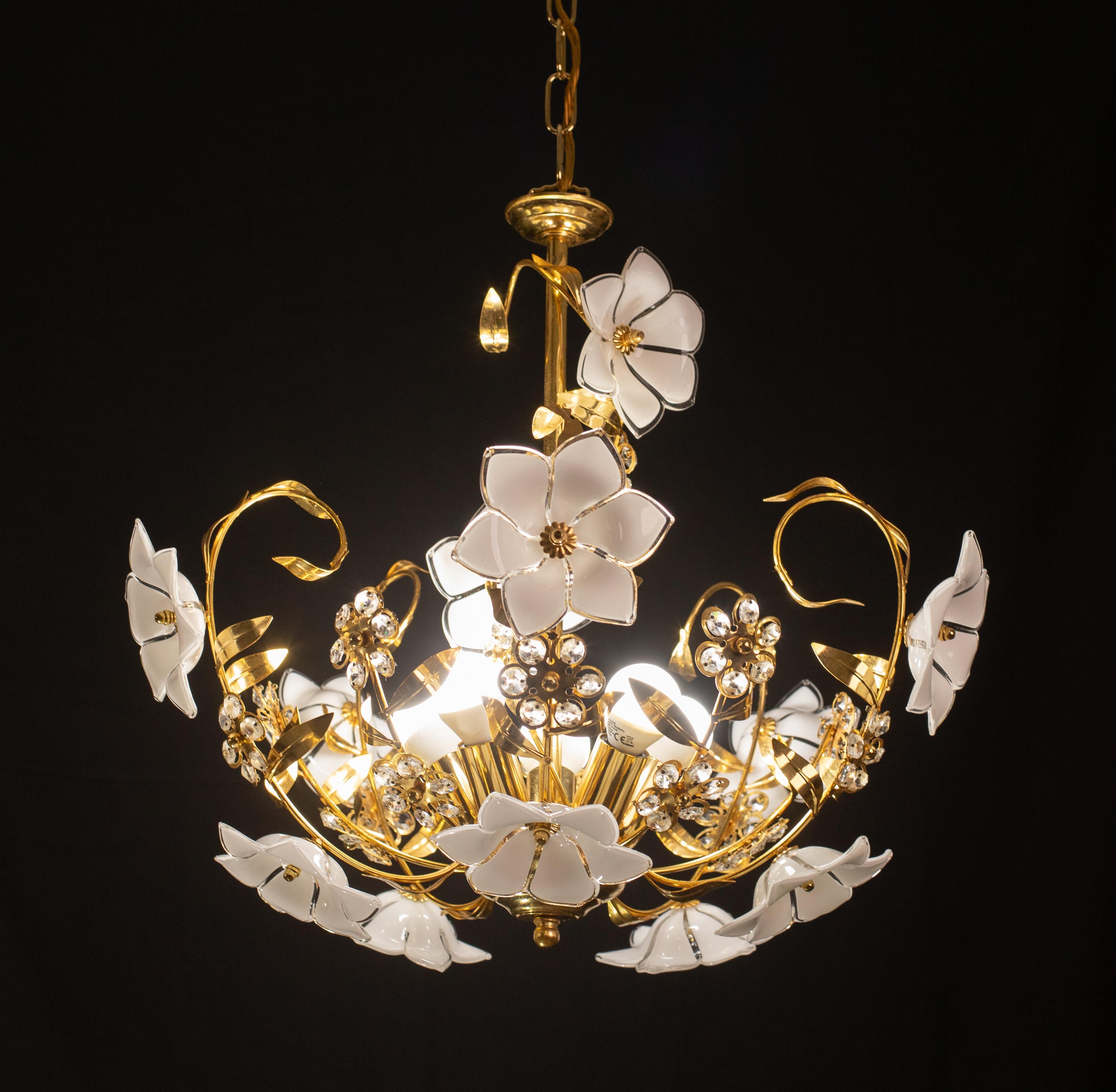Vintage Murano Glas Kronleuchter voller weißer Blumen aus Muranoglas.
Der Kronleuchter hat 5 Lichtpunkte mit E14-Fassung, die für Usa-Standards umverdrahtet werden können.
Der Rahmen ist aus Goldbad in gutem Vintage-Zustand.
Die Höhe des