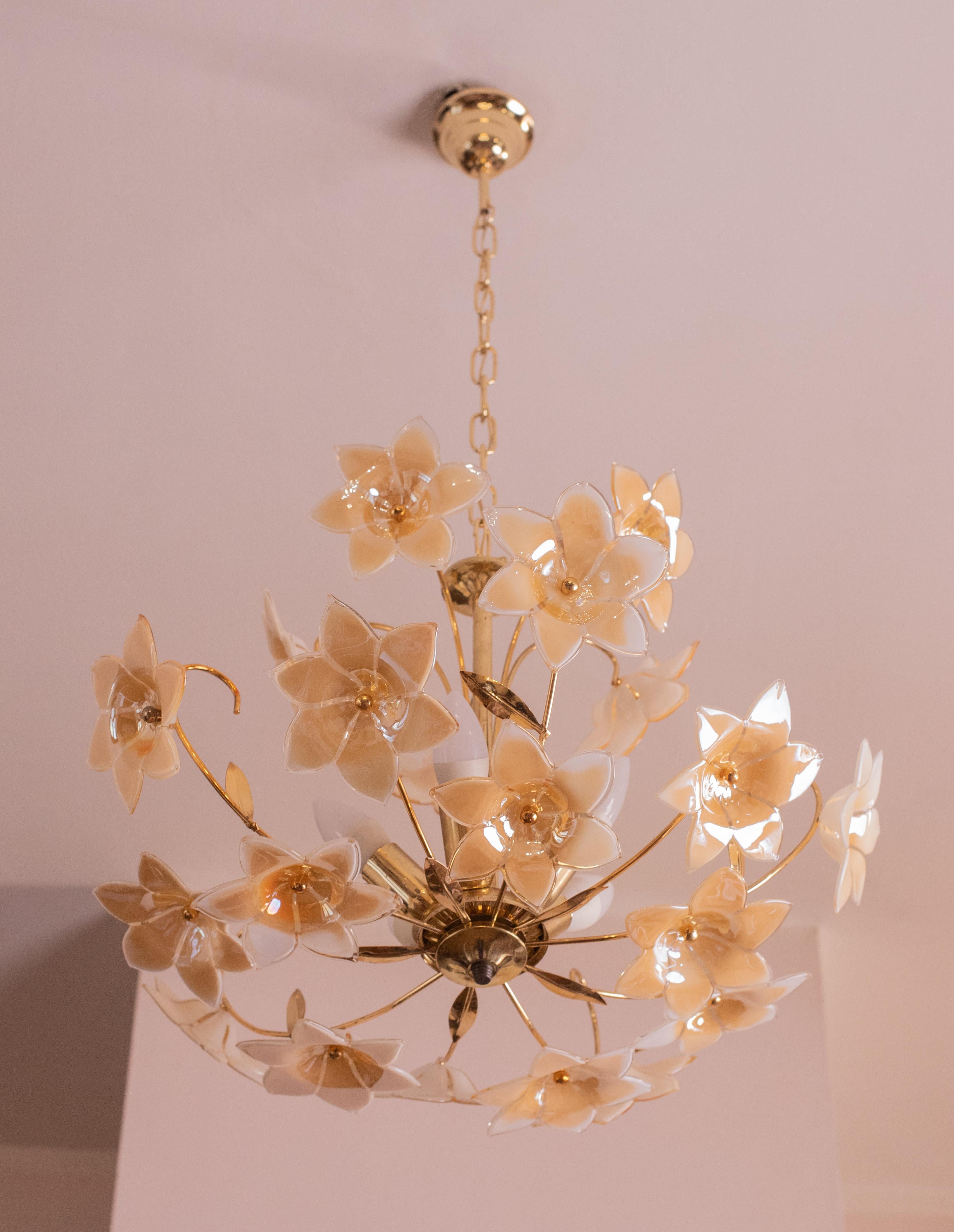 Stunning Murano chandelier with iridescent orange flowers.

The peculiarity of this glass is that it changes the shades of its color depending on the light it gets.

The chandelier mounts 5 light points e14 European standard.

The rosette and