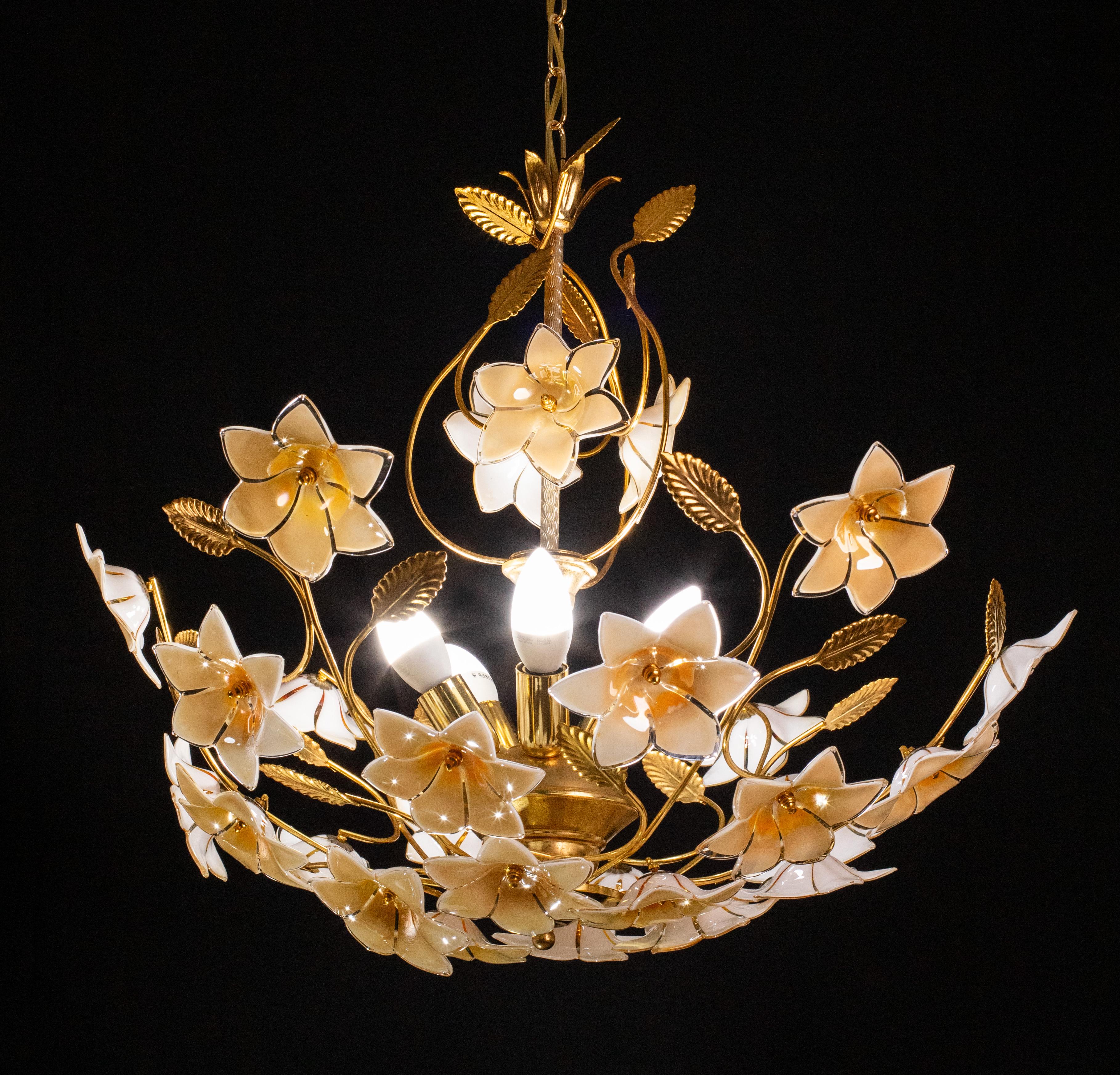 Stunning Murano chandelier with iridescent orange flowers.

The peculiarity of this glass is that it changes the shades of its color depending on the light it gets.

The chandelier mounts 5 light points e14 European standard, possible to rewire for