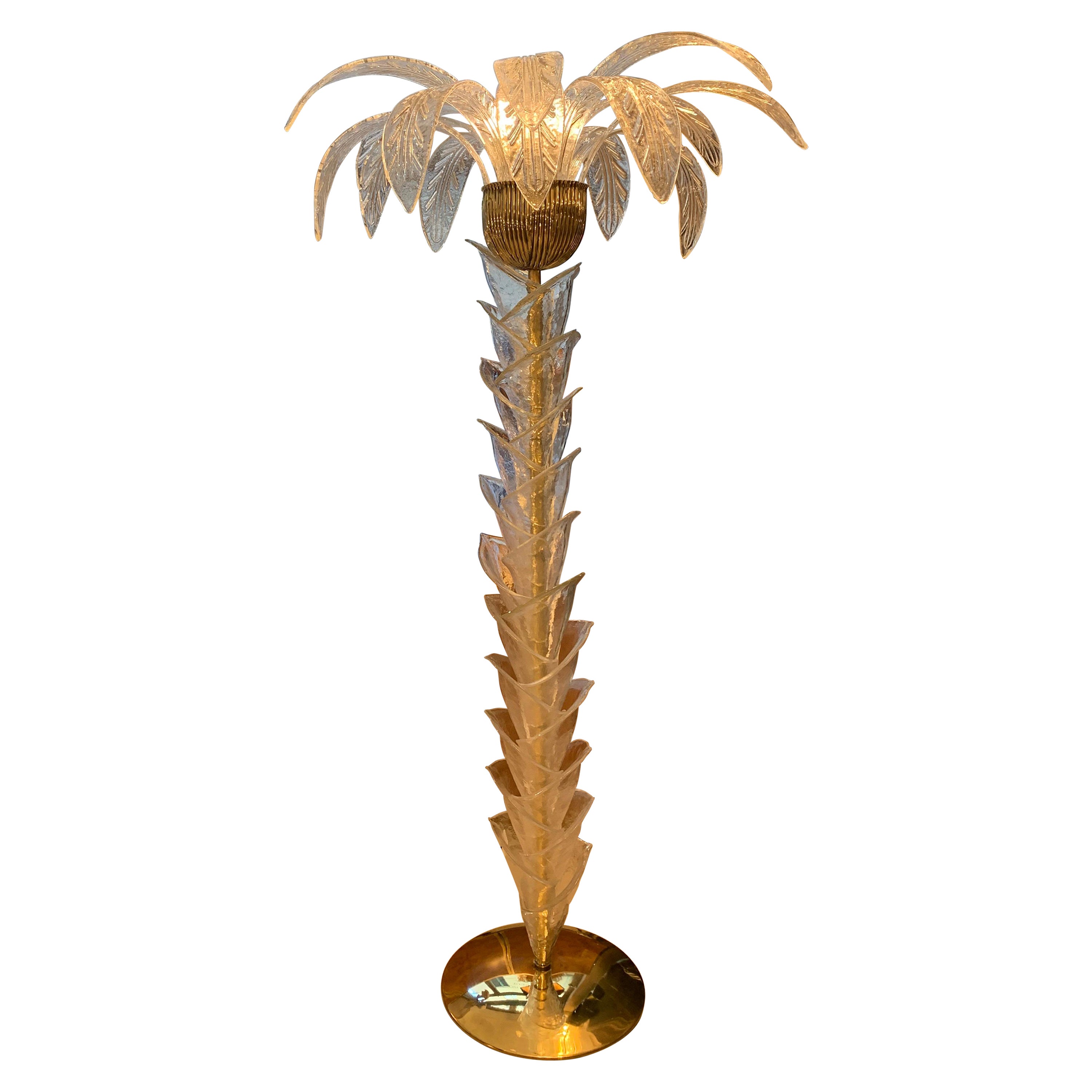 Murano clear glass palm tree floor lamp with brass base and fittings, three light bulbs. The floor lamp is also a sculpture that reproduces with the clear hand blown Murano glass pieces the trunk and the leaves of a palm.
  
