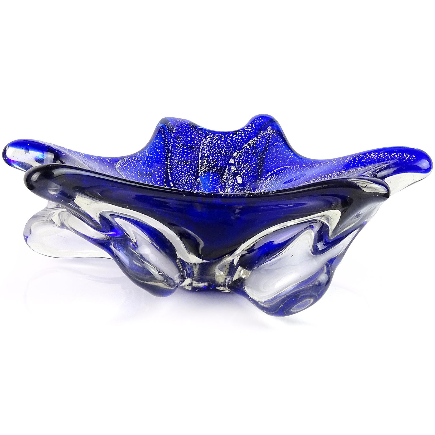 Beautiful vintage Murano hand blown cobalt blue and silver flecks Italian art glass biomorphic bowl. The piece is cased over with clear glass, and pulled from underneath to create the shape. It has very heavy silver leaf throughout. A statement