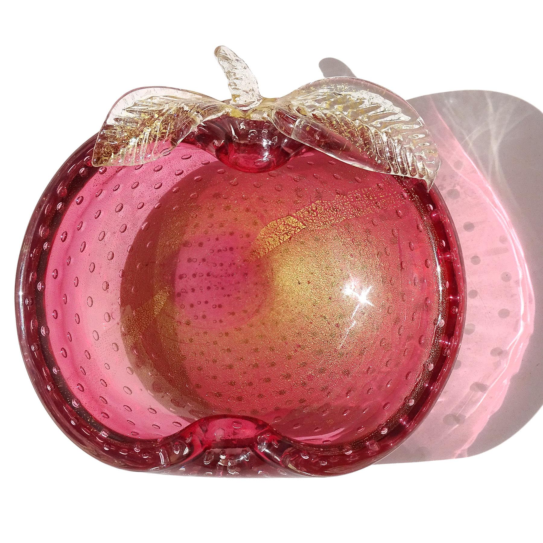 Beautiful vintage Murano hand blown cranberry pink and gold flecks Italian art glass apple shaped decorative bowl / vide poche. The piece is made in the bullicante technique, with even bubbles throughout. It has leafs and a stem attached to the rim,