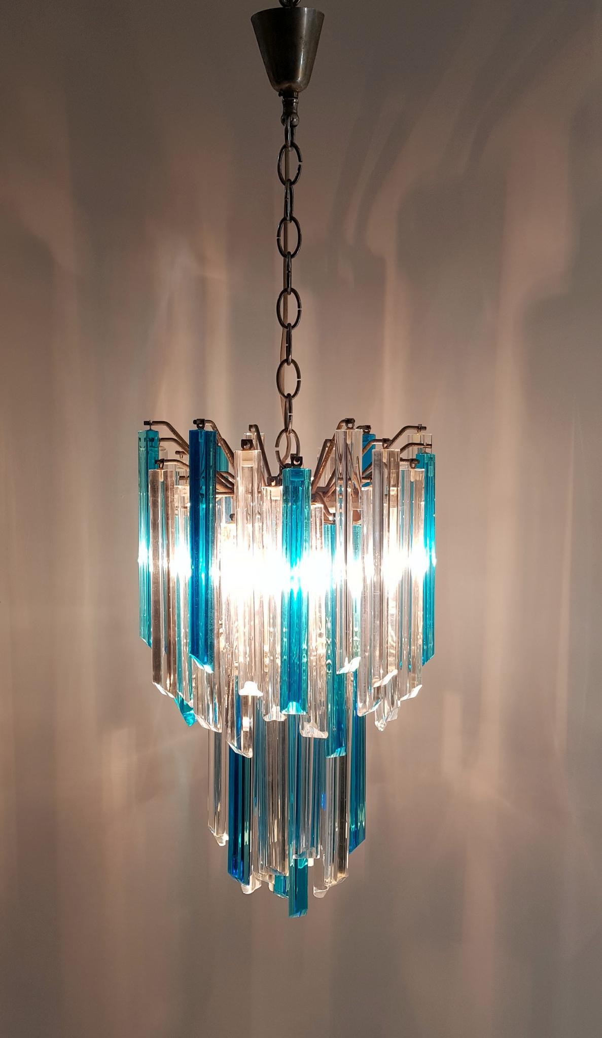 A crystal so-called triedri chandelier manufactured by Venini, Murano. The crystals are in clear and blue and are hangs in tiers on a steel chromed base. Gives magnificent light and reflections in the room. The structure is 60 cm high and the chain