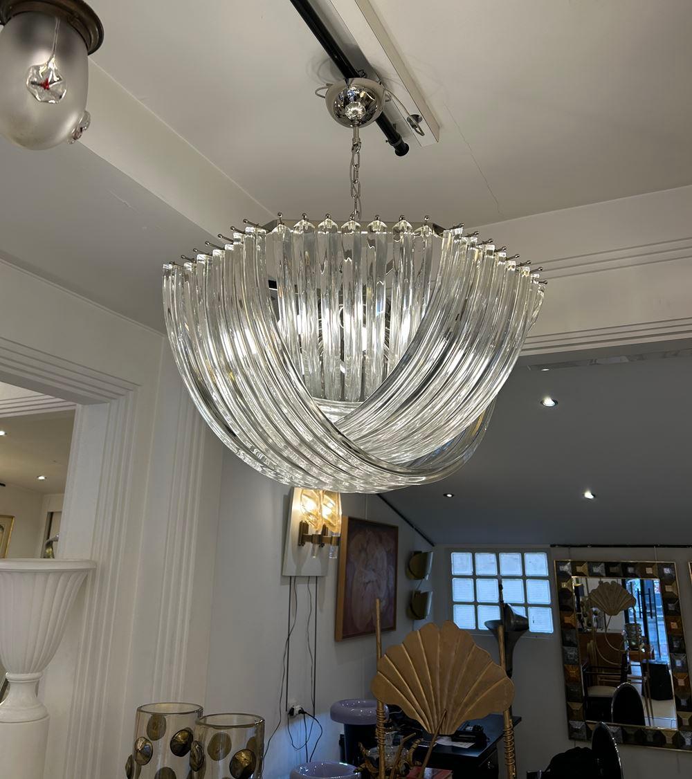 Lampadario in vetro trasparente soffiato a mano di Murano.
Apparecchio in cromo placcato.

Diametro 80 cm
L'altezza del cestino con i soli bicchieri è di 40 cm.
L'altezza totale con la catena è di 100 cm
Can può essere regolato con la catena

6