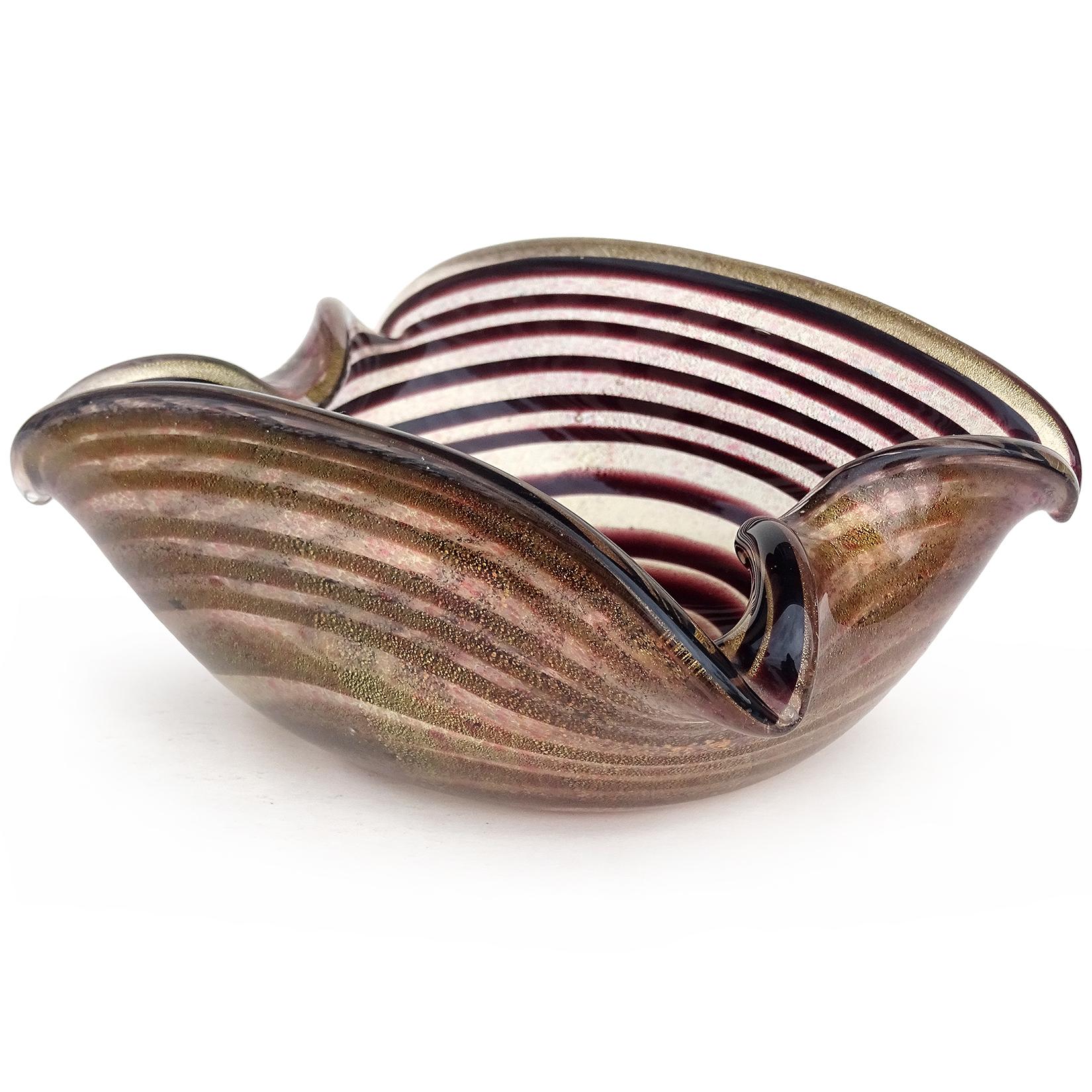Beautiful vintage Murano hand blown dark purple optic swirl and gold flecks Italian art glass bowl. The bowl has high sides with decorative indents on the ends. The glass has tiny little color dots of blue and pink. It is also profusely covered in