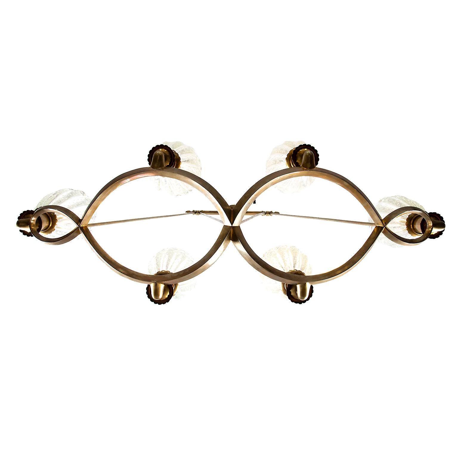 This long and elegant six light fixture is stunning with its thick clear glass bubble inclusion Murano shades and fine oval bronze rings suspended by brass rods.
Wired for North America.