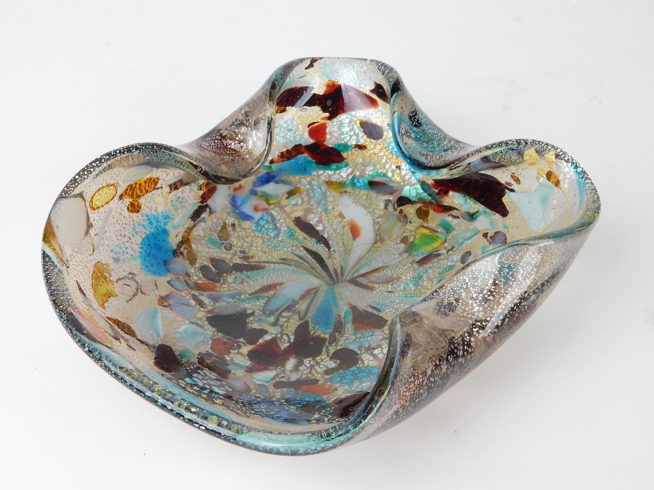 Fabulous art glass bowl, or ashtray designed by Dino Martens.
circa 1960s bowl full of colorful details. 
Interior has bits of teal, red, green and brown. Wavy edge with outside flooded in rosey gold flecks.
Measures 7-3/4 X 7