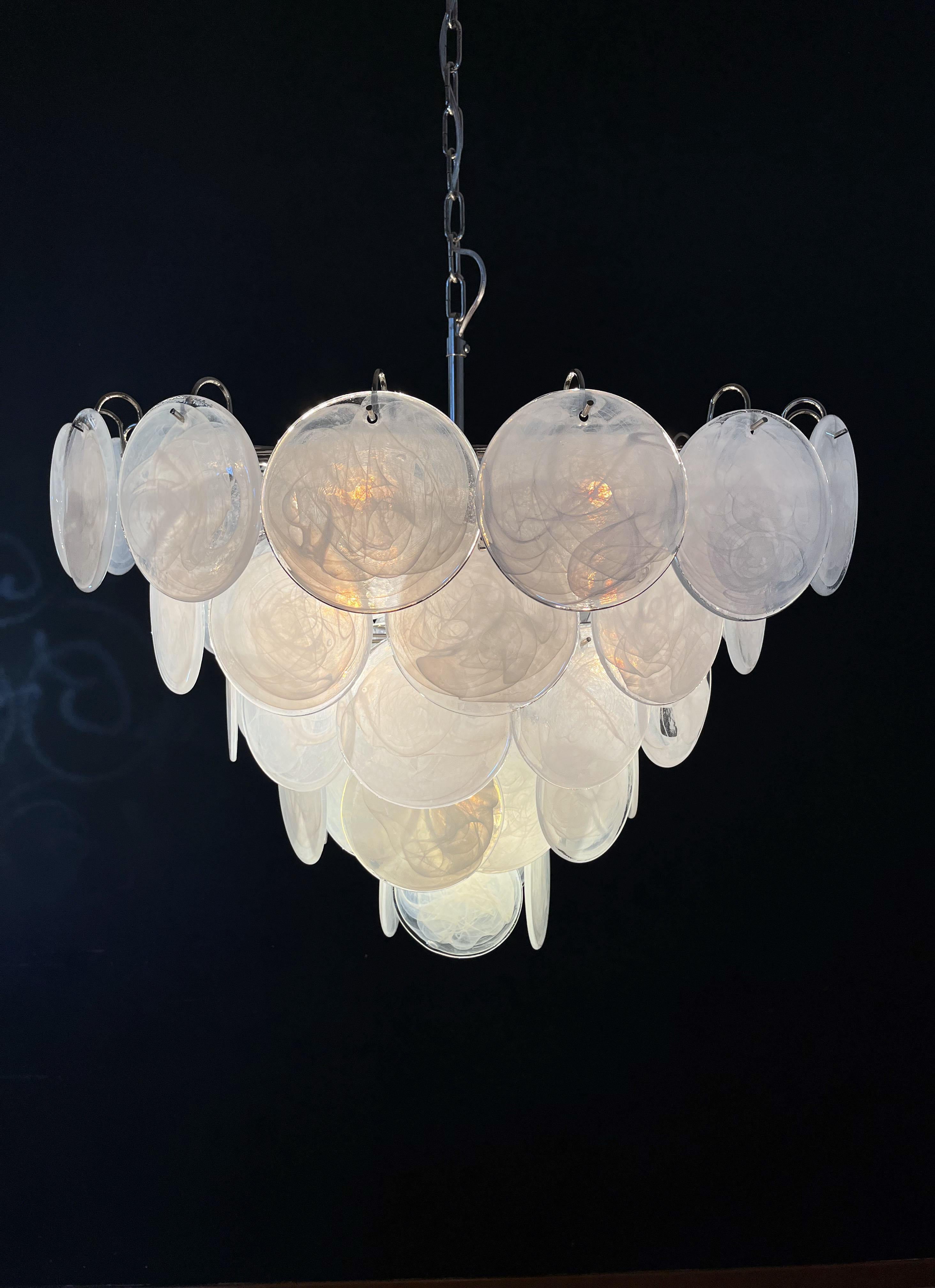 Italian Murano chandelier. The chandelier has 57 Murano white albaster iridescent glass disks. The glasses are now unavailable, they have the particularity of reflecting a multiplicity of colors, which makes the chandelier a true work of art. Nickel