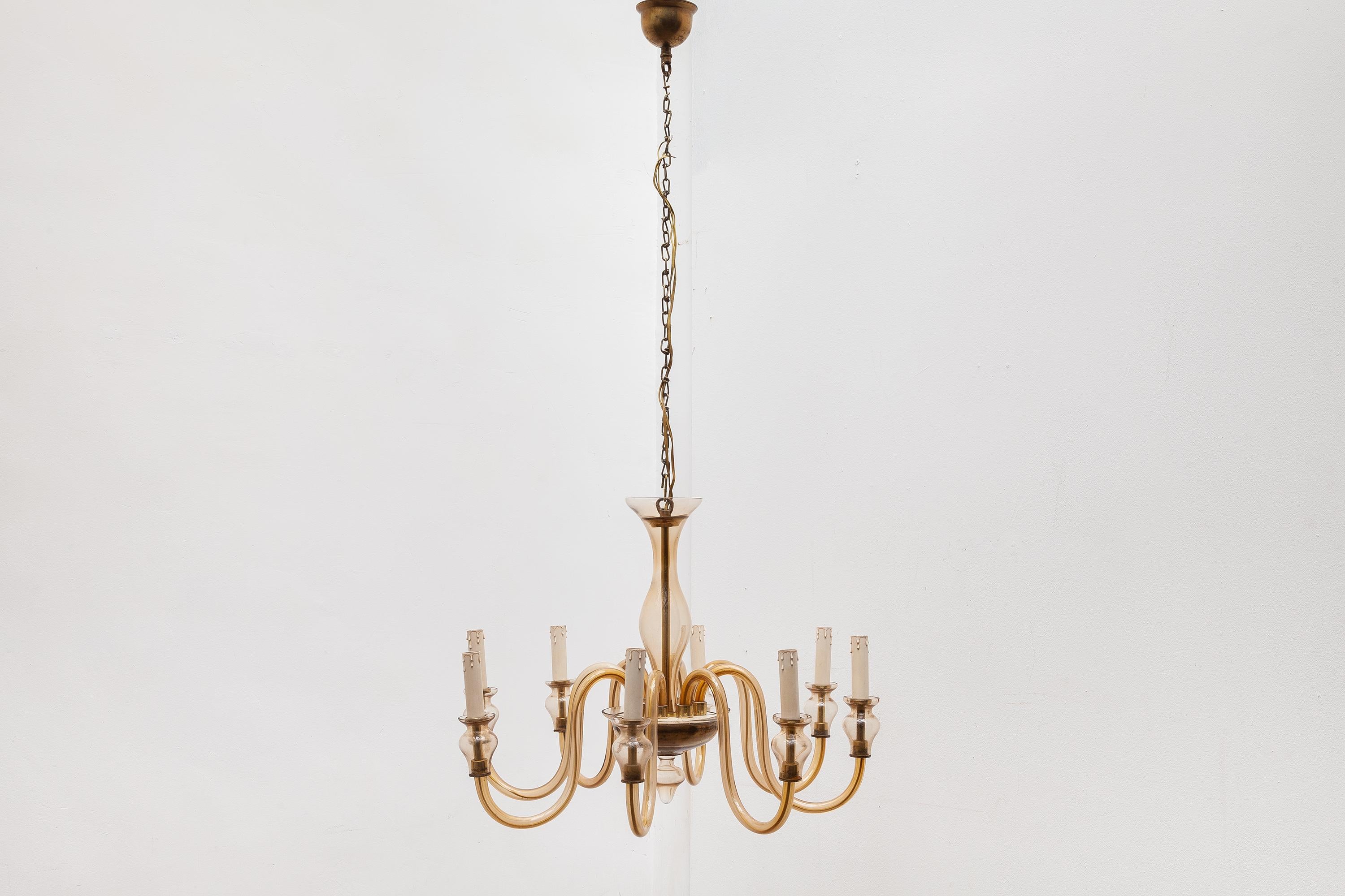 Antique Murano chandelier in a warm toned clear glass with brass accents. Lit by 8 bulbs.