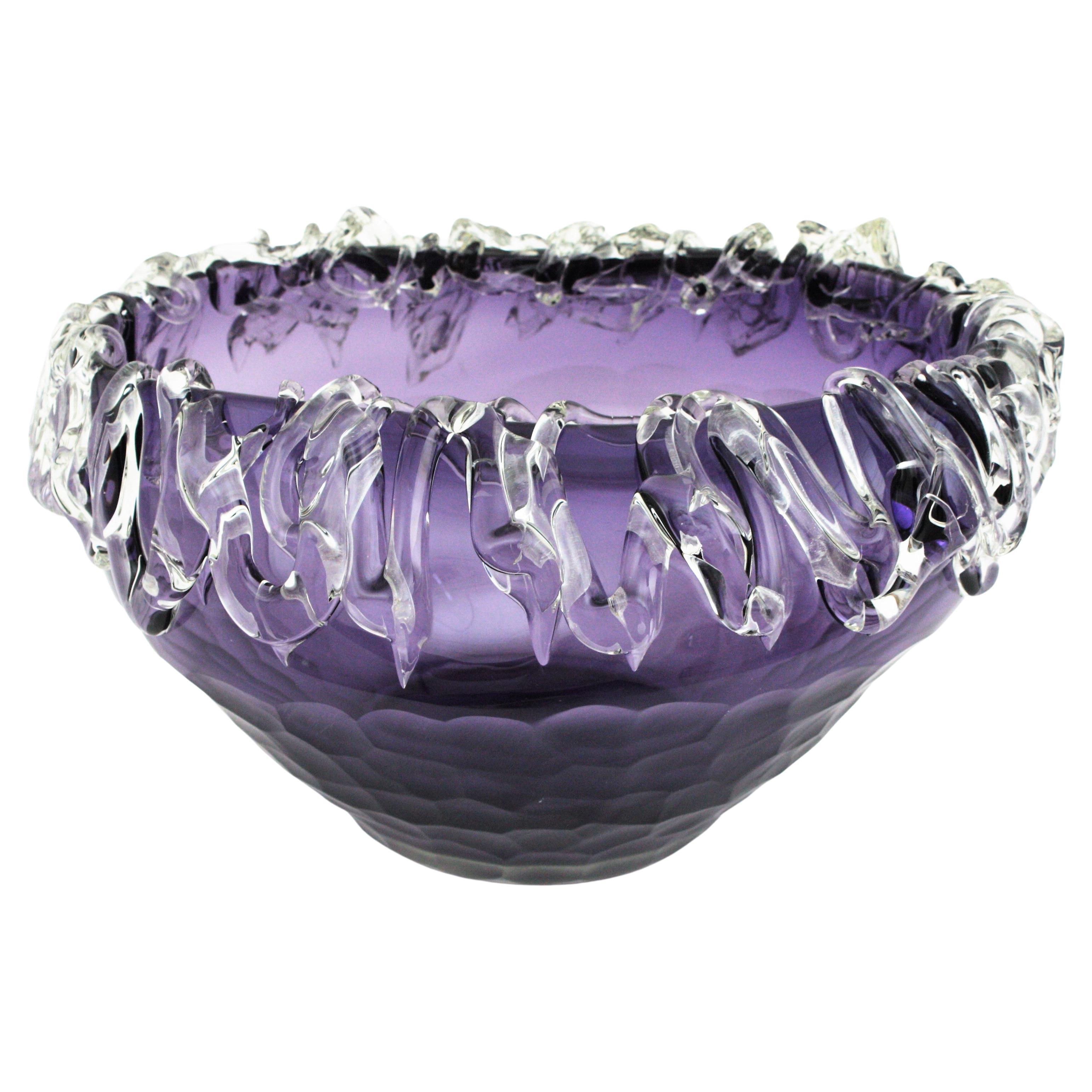 Murano glass centerpiece vase in purple and filigree clear glass rim, Italy, 1950s.
Stunning blown glass purple centerpiece with faceted body and heavily adorned rim by applied clear glass free-from details. 
Eye-catching color and rare design.
This