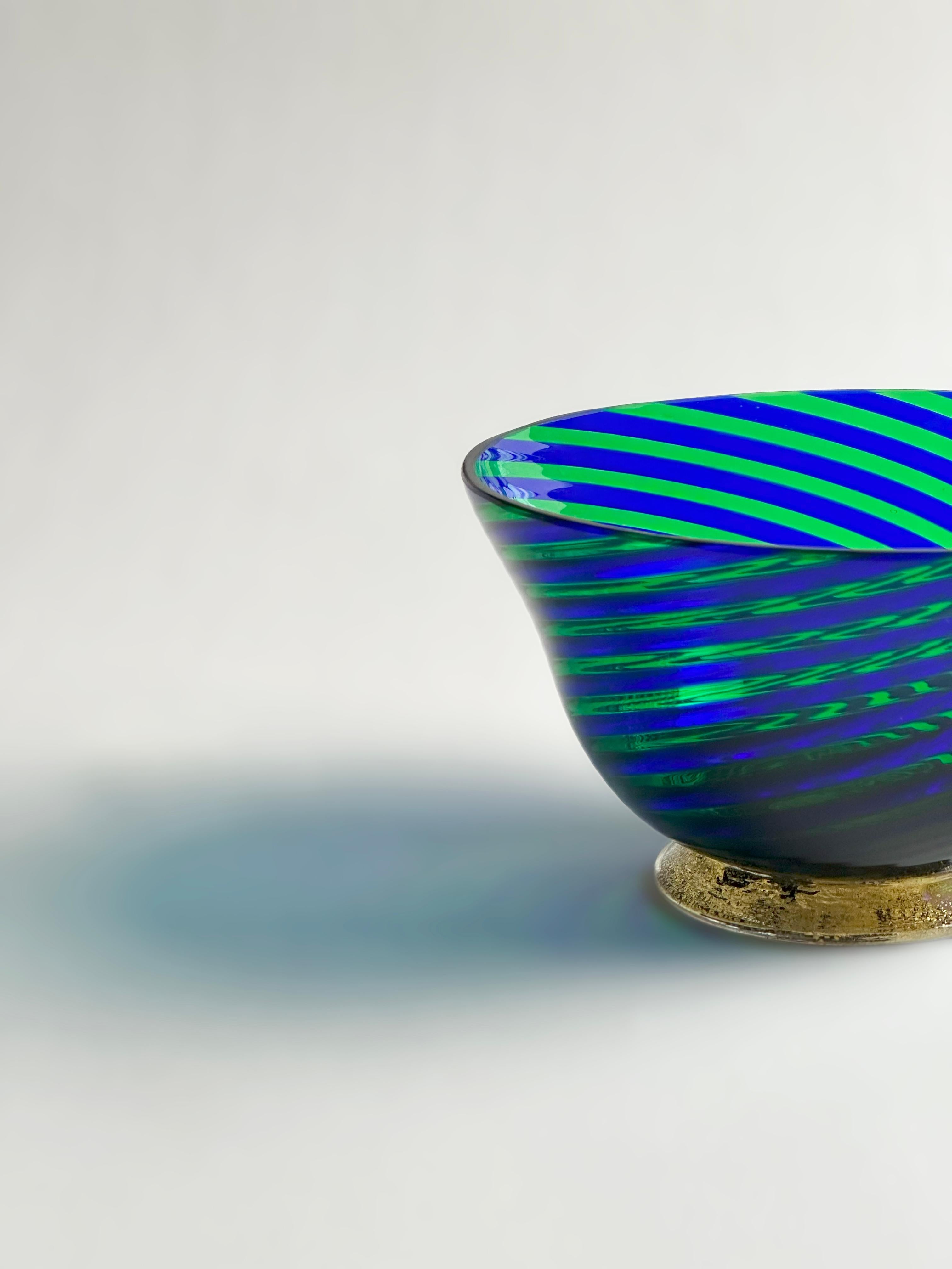 Realizzata a mano negli anni '70 sull'isola veneziana di Murano, questa ciotola decorativa in vetro è un ottimo esempio della tradizionale tecnica della filigrana, in cui canne di vetro colorate vengono fuse e soffiate con cura per creare motivi