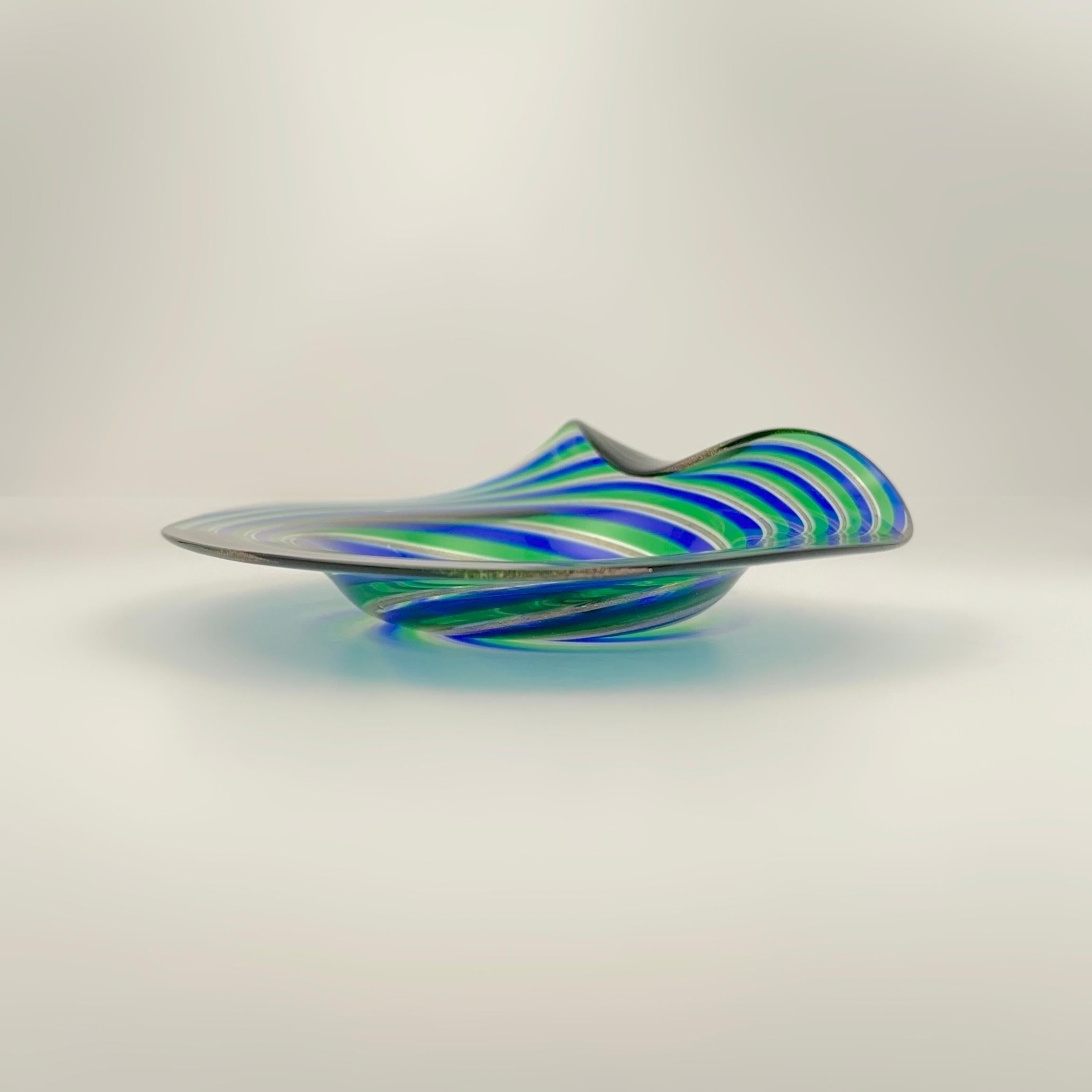 A vibrant Murano filigrana glass dish, attributed to Cenedese & Alberelli, Italy, circa 1970s. 

This small decorative dish showcases classic Murano glass artistry, with alternating swirls of green and cobalt blue glass, accented by fine ribbons of