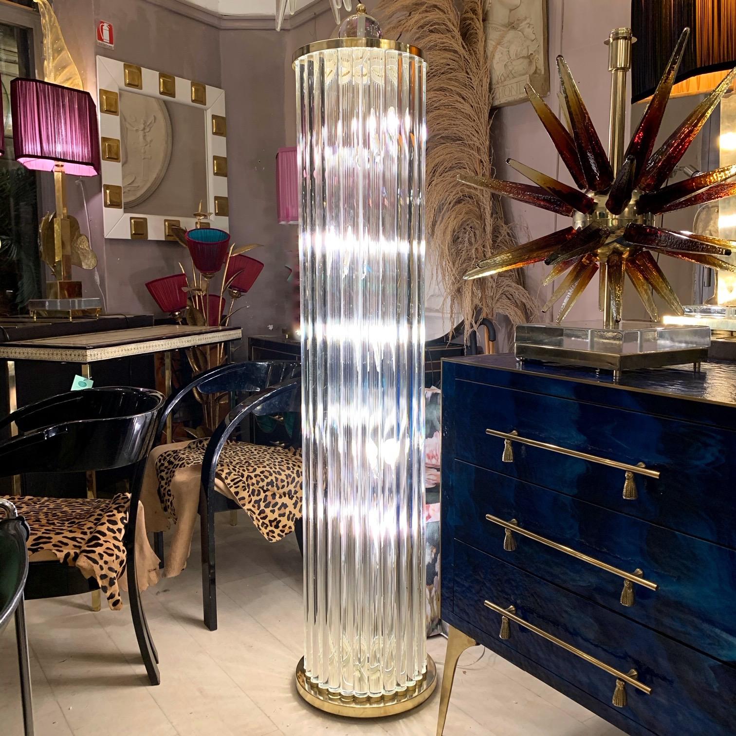Murano floor lamp with clear glass rods, brass base and top. The floor lamp is a clear glass sculpture with column shape, on the top there is a Murano clear glass sphere. Five-bulb lights.