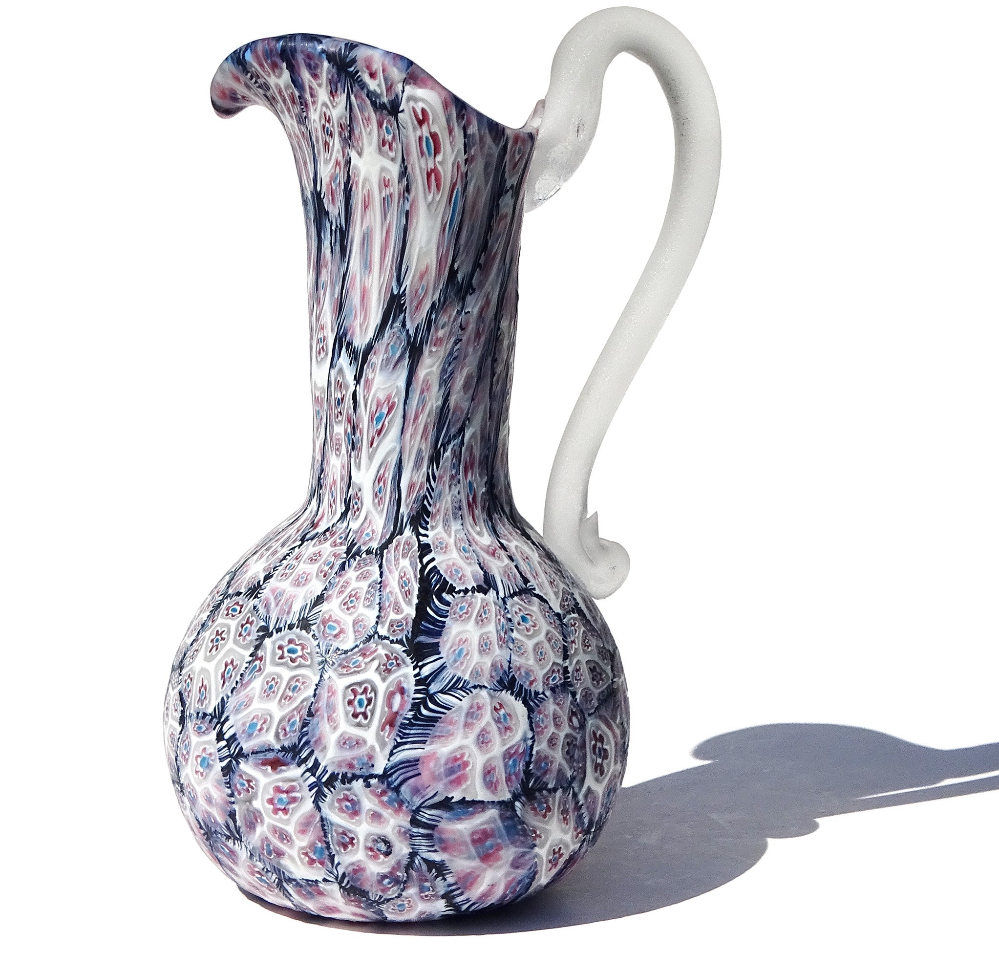 Beautiful vintage Murano hand blown black, white, blue, pink millefiori flower mosaic Italian art glass pitcher / vase. The piece is documented to designer Ermanno Toso, for Fratelli Toso, circa 1960s. The pattern is a version of 
