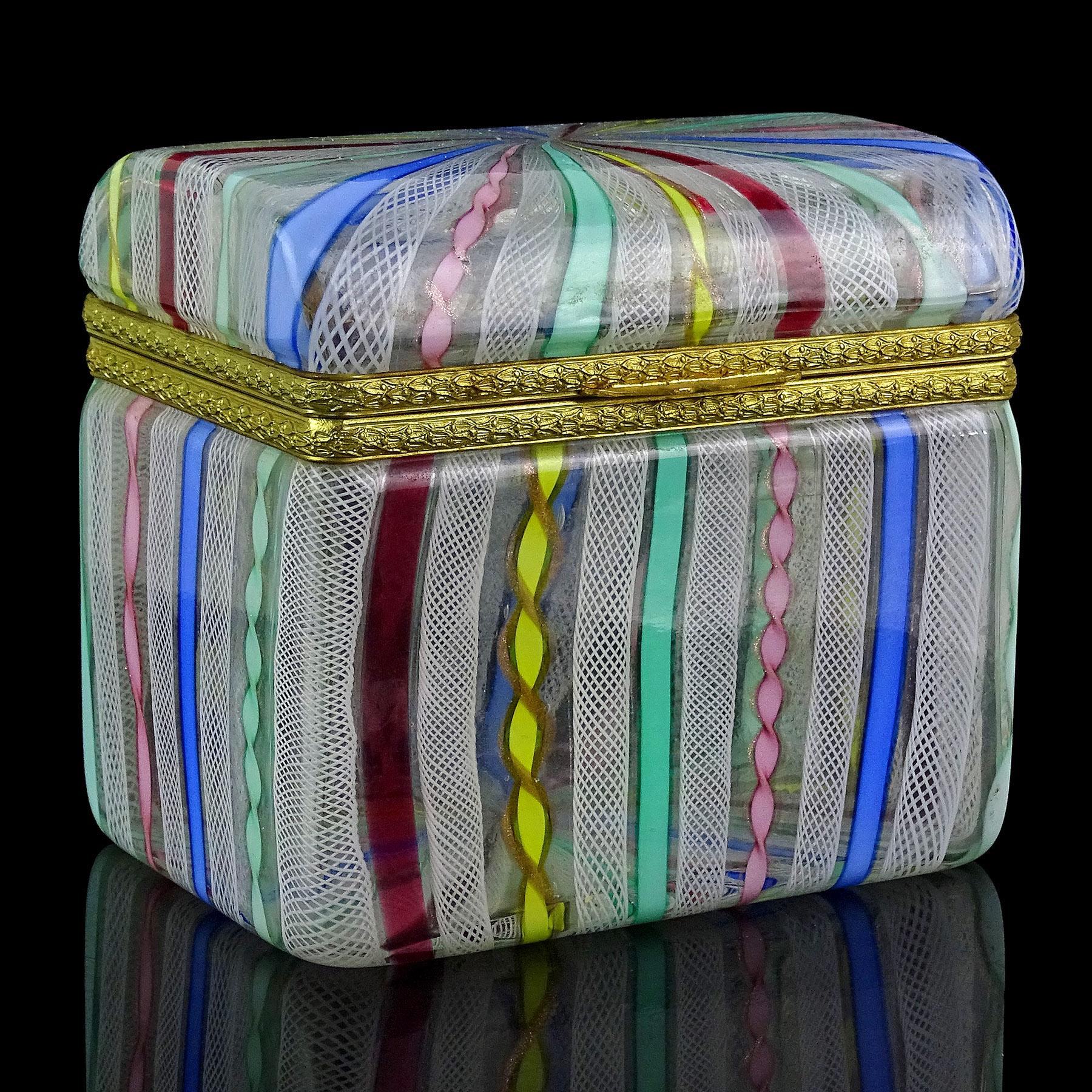 Gorgeous vintage Murano hand blown multi-color twisting rainbow ribbons Italian art glass casket jewelry box. Documented to the Fratelli Toso company. There are pink, yellow, teal green, blue and white colors. The piece has a treasure chest / trunk