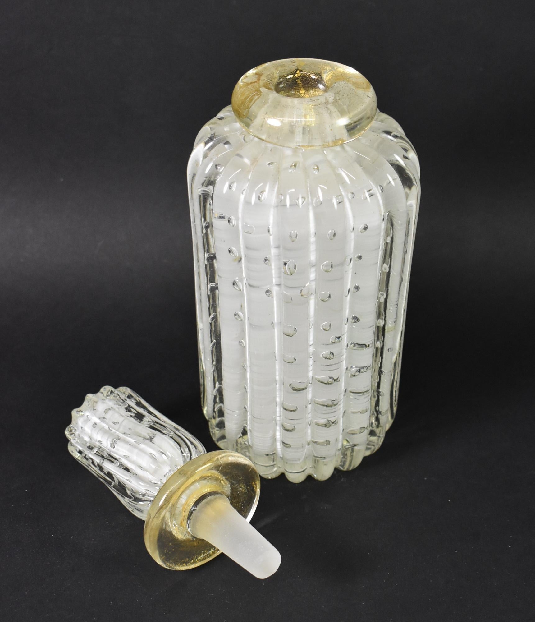 Beautiful decanter made of frosted and clear glass with bubbles. Gold on the top lip and base of the stopper; some missing due to wear and use. Very light scratches on the base. No chips or cracks. 10 3/8