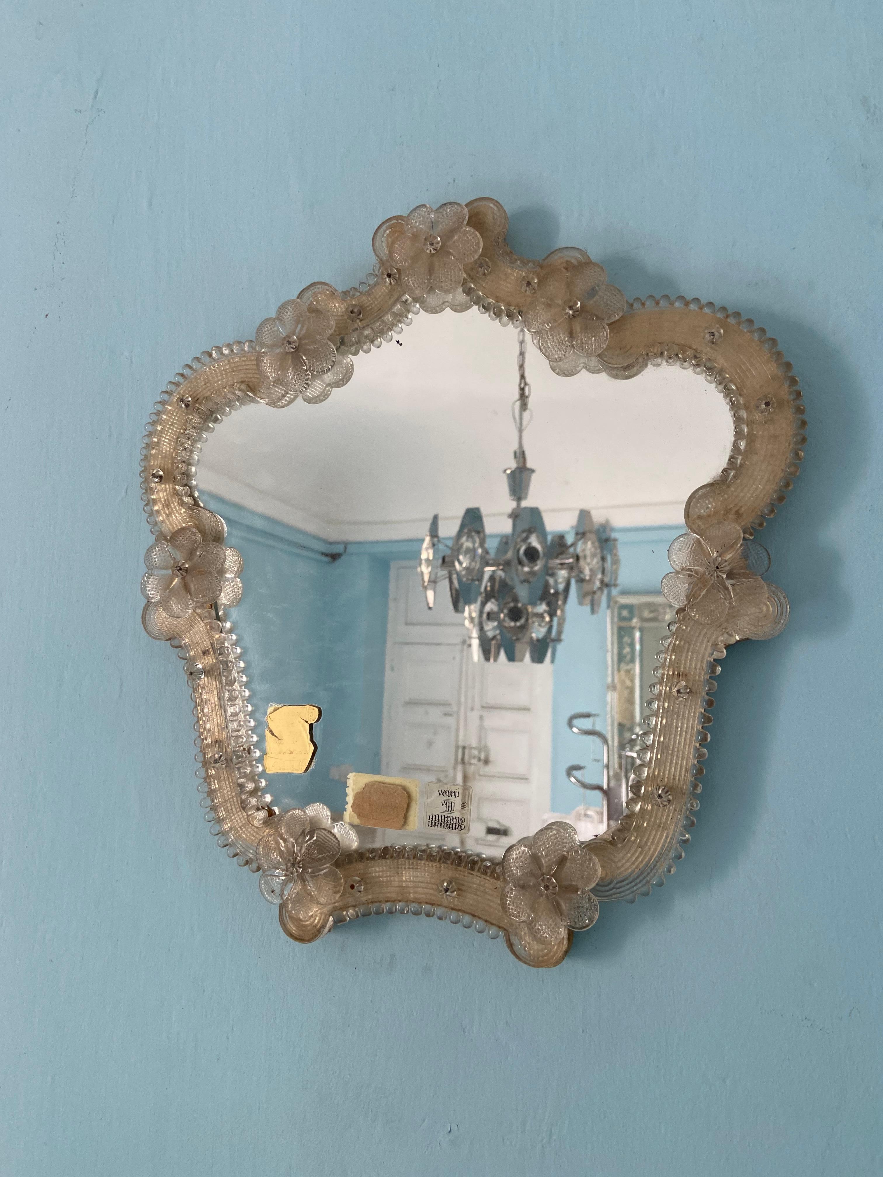 Miroir en verre de Murano des années 1960 avec des fleurs délicates. Le verre du miroir lui-même présente une belle patine. A accrocher au mur.