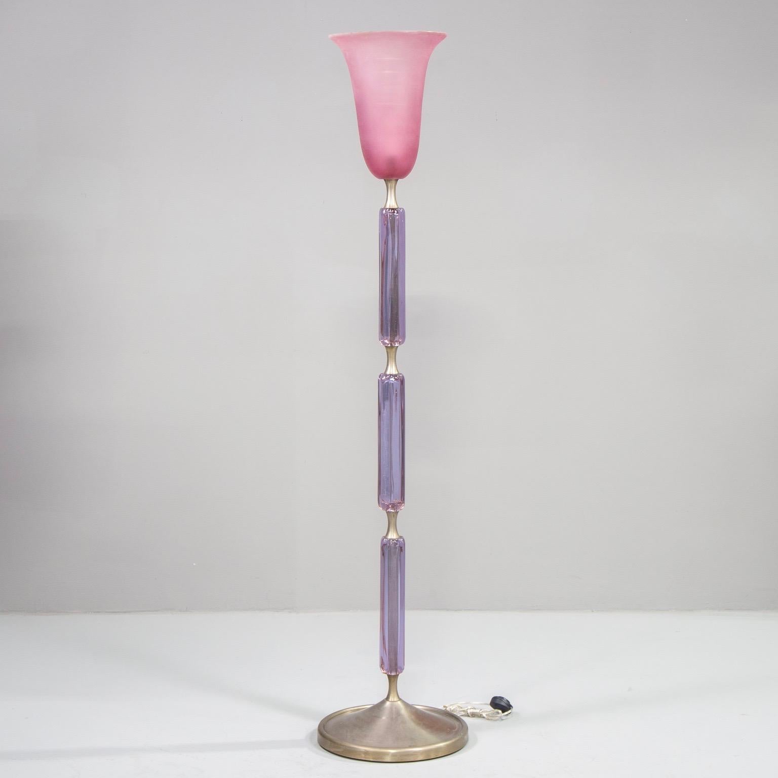 Attributed to Venini, this circa 1940s floor lamp features a metal base with three amethyst colored Murano glass elements covering the center support and a pink globe. New wiring for US electrical standards.

Measures: Base diameter 16”
Top globe