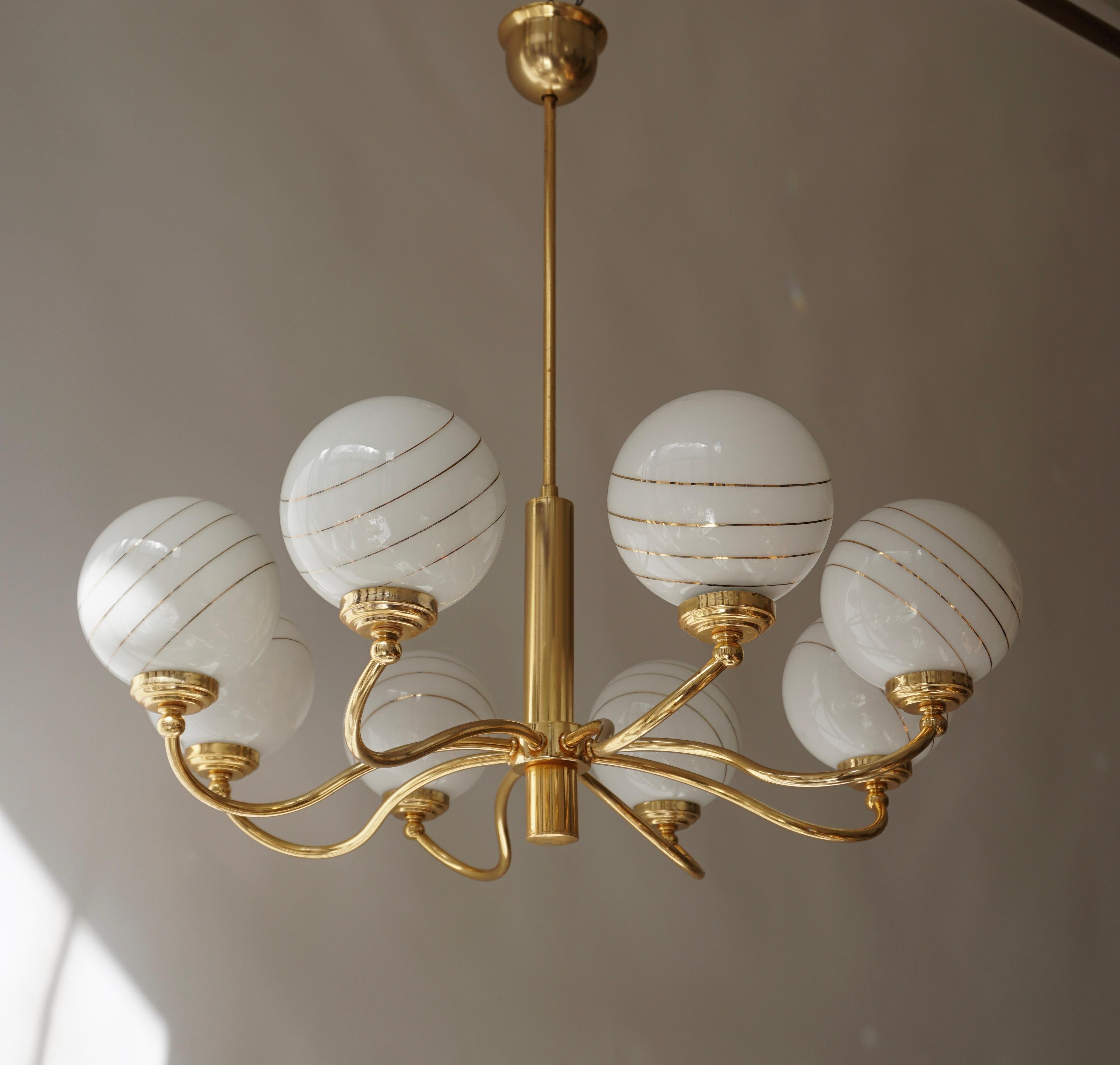 Italian Murano glass and brass eight-arms chandelier.

Measures: Diameter 70 cm.
Height 70 cm.
Eight E14 bulbs.

.