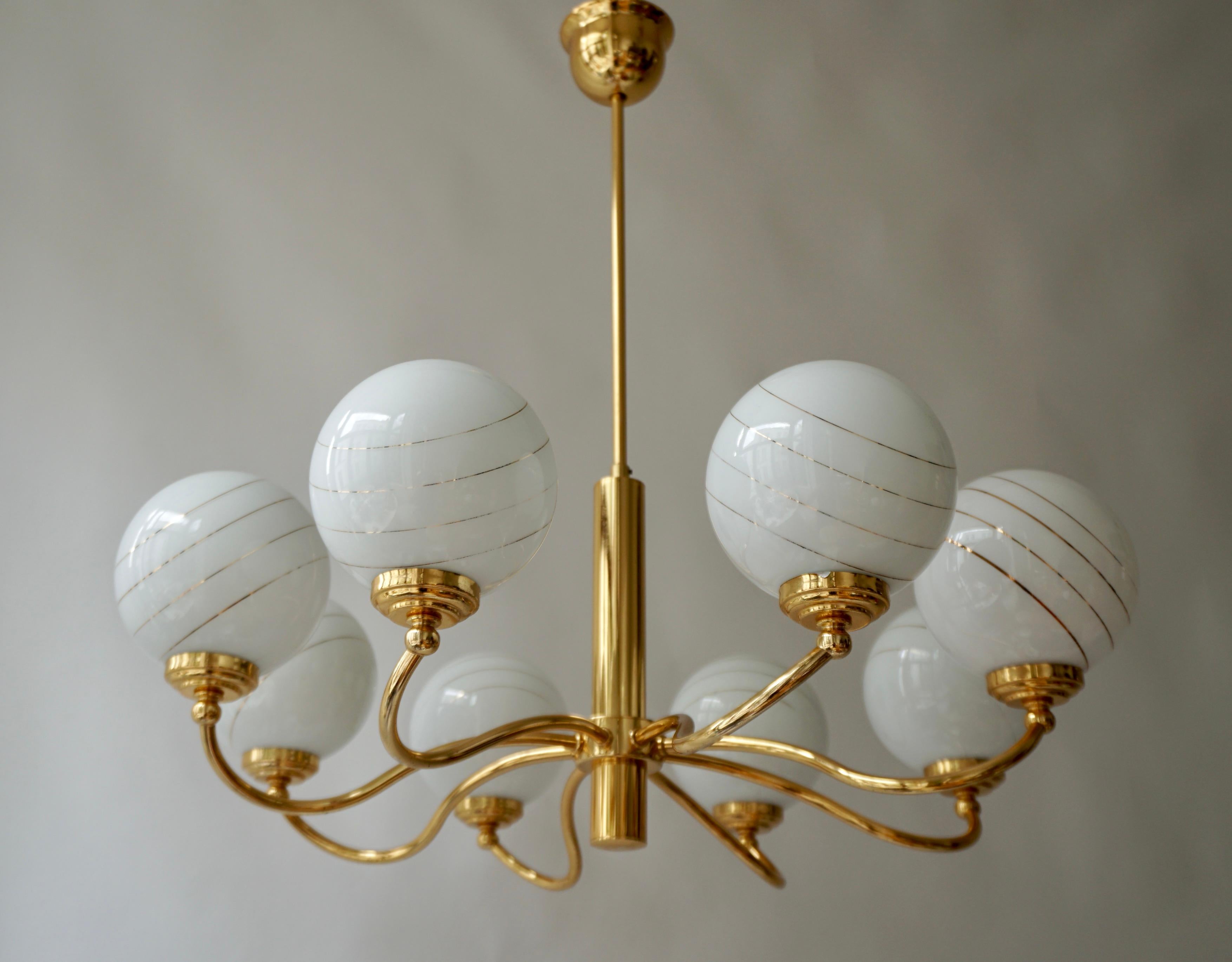 Italian Murano glass and brass eight-arms chandelier.

Measures: Diameter 70 cm.
Height 70 cm.
Eight E14 bulbs.

.