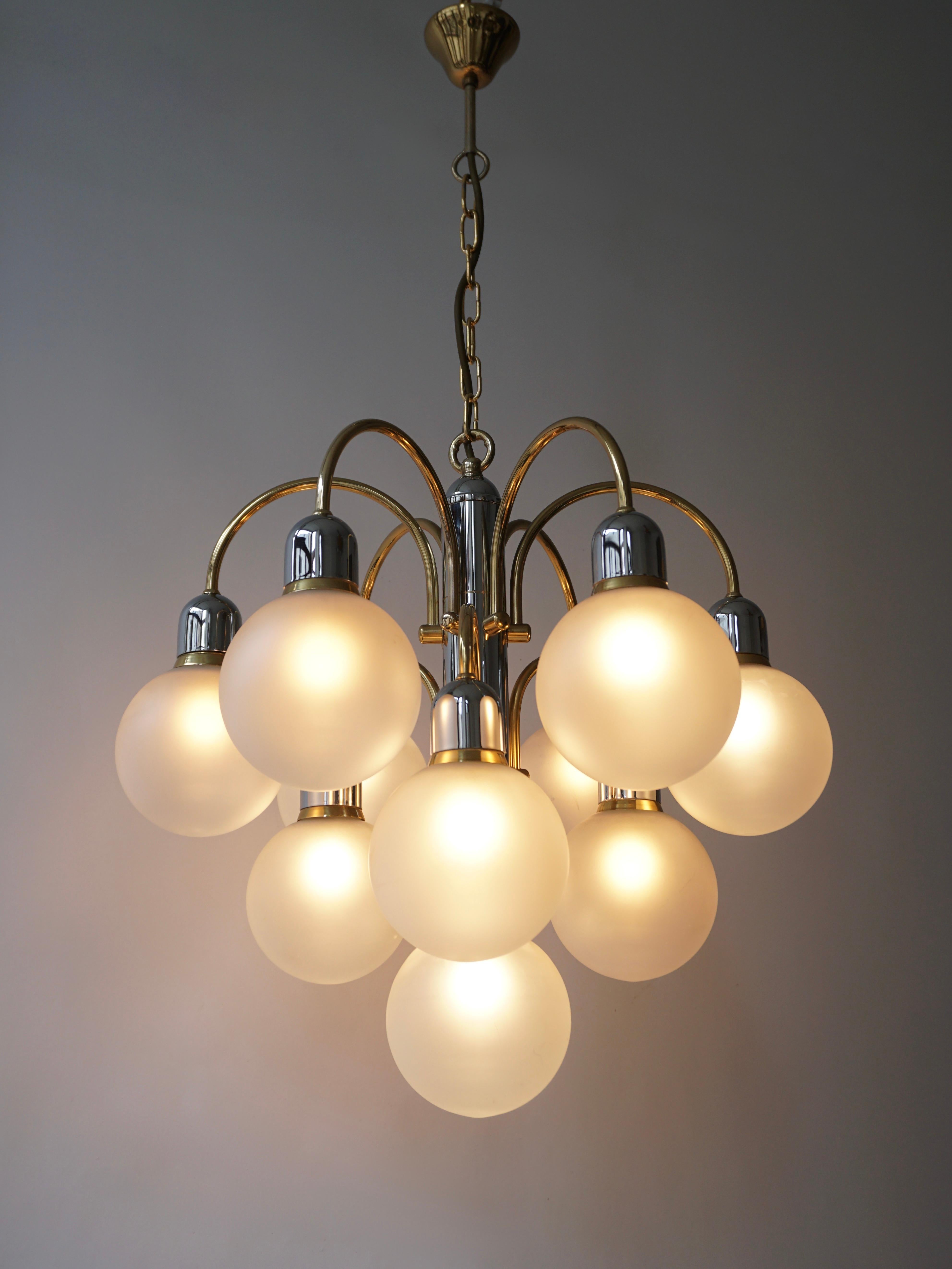 A Italian chandelier in brass with ten arms of which each hold a Murano glass sphere. The bulbs are divided over three levels, creating an extravagant look. 
The light created by this chandelier is very pleasant and ambient.

Measures: Diameter