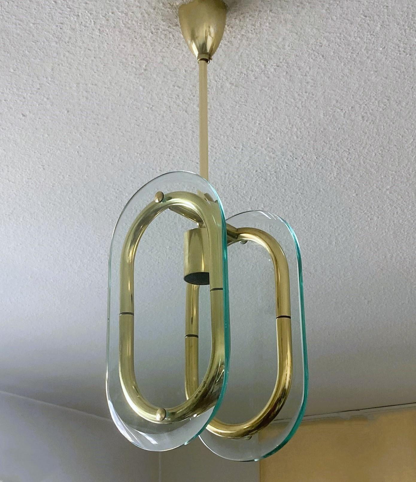 Midcentury Murano glass and Brass pendant attributedd to Fontana Arte, designed and manugactured in Italy in the 1950's. Organically shaped double lens cut panels of thick profiled Murano glass fitted within a natural brass rings suspended from
