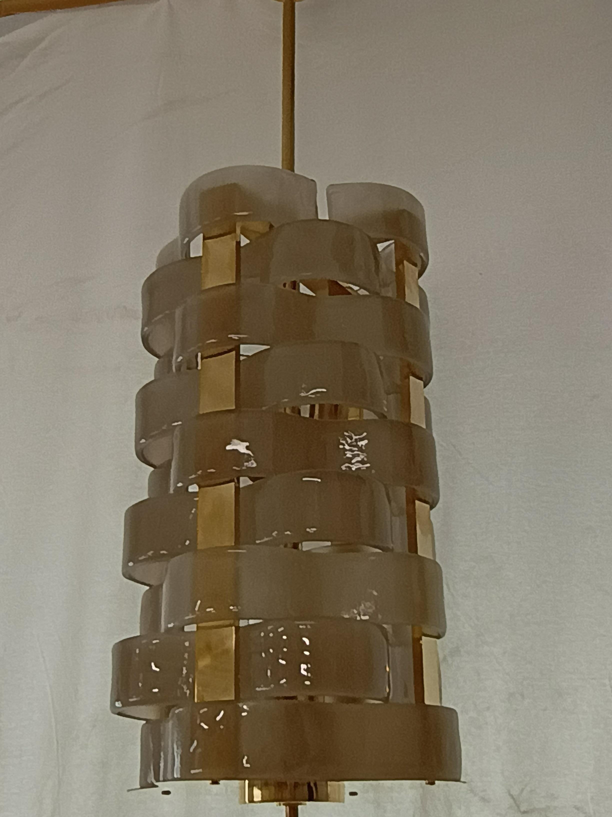 Design in woven Murano glass for this smoky colored chandelier, its style is elegant and linear.

The chandelier is in Murano glass, dove gray or smoked color. The shape of its glasses is very particular, positioned alternately one above the other,