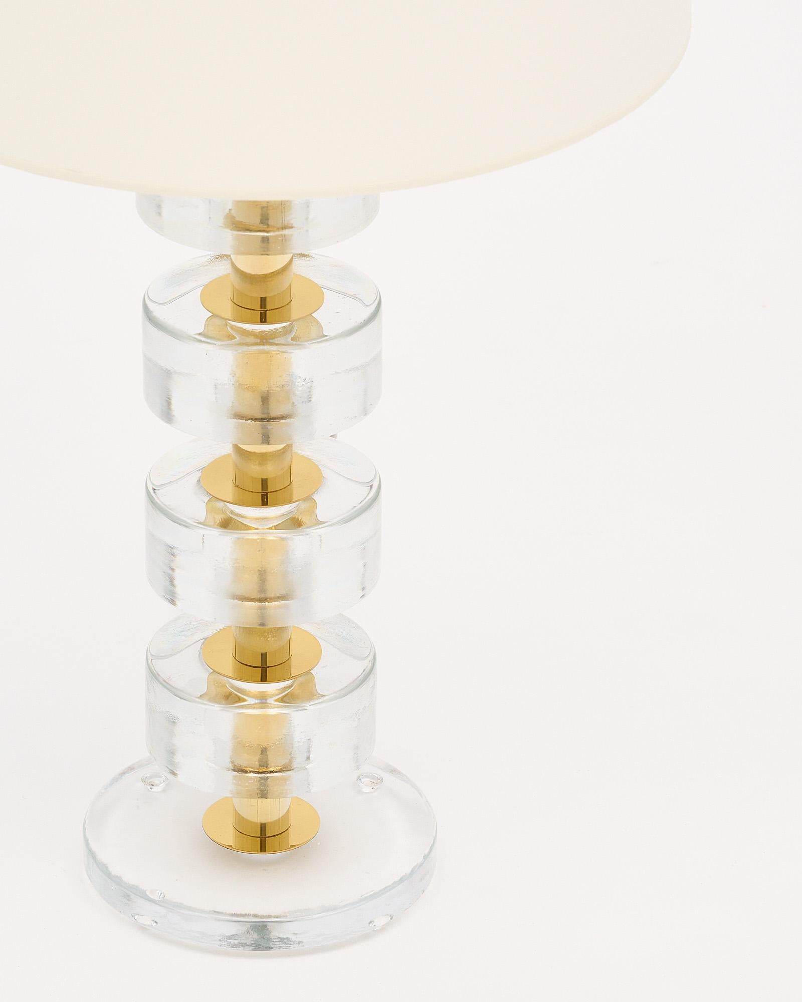 Pair of modern lamps made with brass structures and clear Murano glass elements. Each piece has hand-blown circular pieces of glass stacked around a brass center. They have been newly wired to fit US standards.

This pair is a special order from our